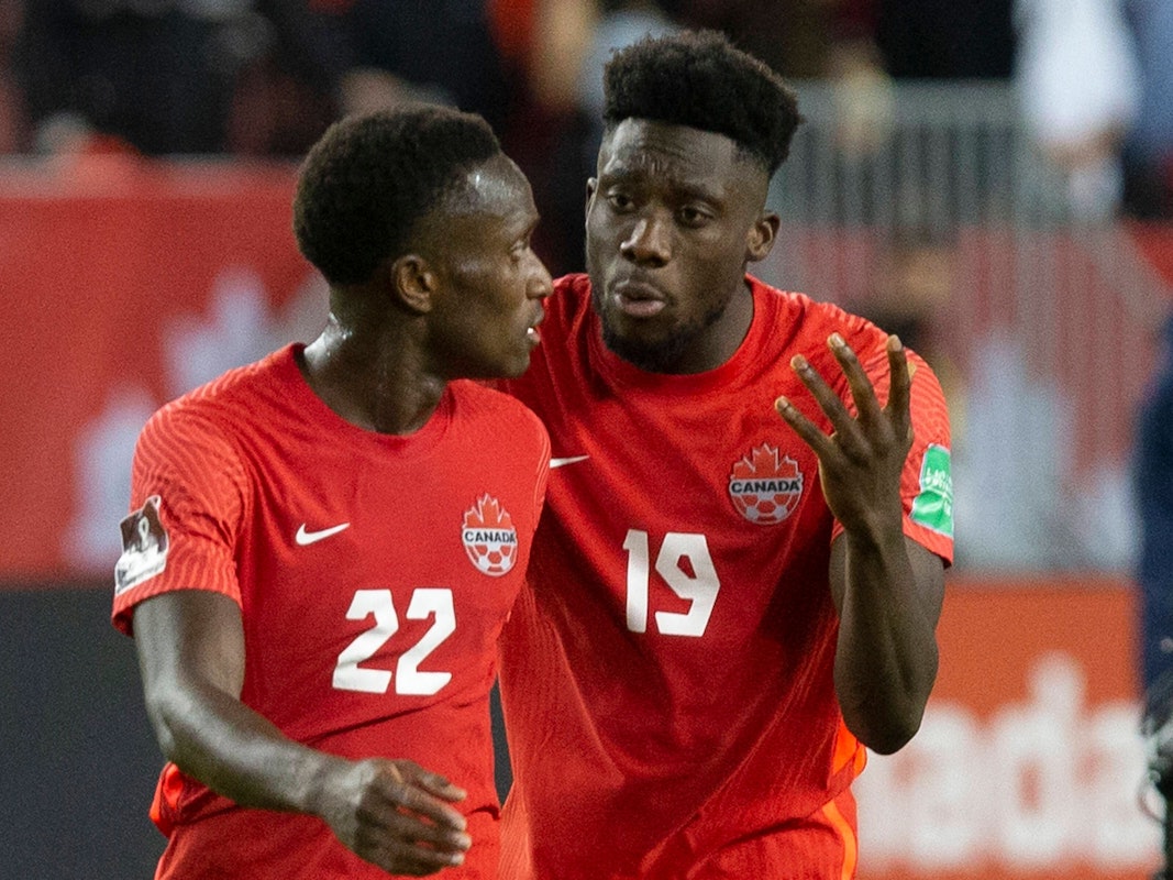 Alphonso Davies und Richie Laryea im kanadischen National-Dress in kritischem Austausch.