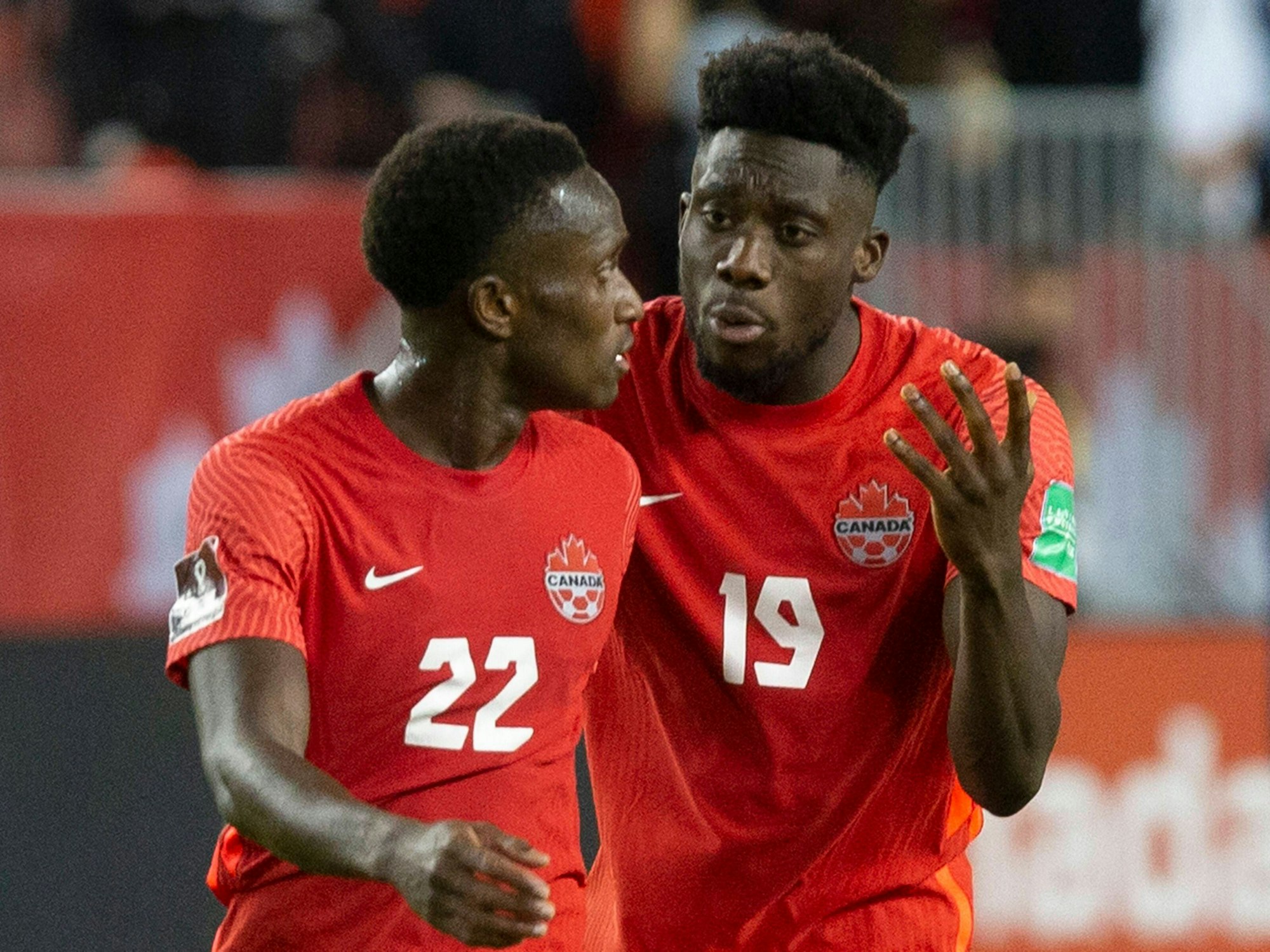 Alphonso Davies und Richie Laryea im kanadischen National-Dress in kritischem Austausch.