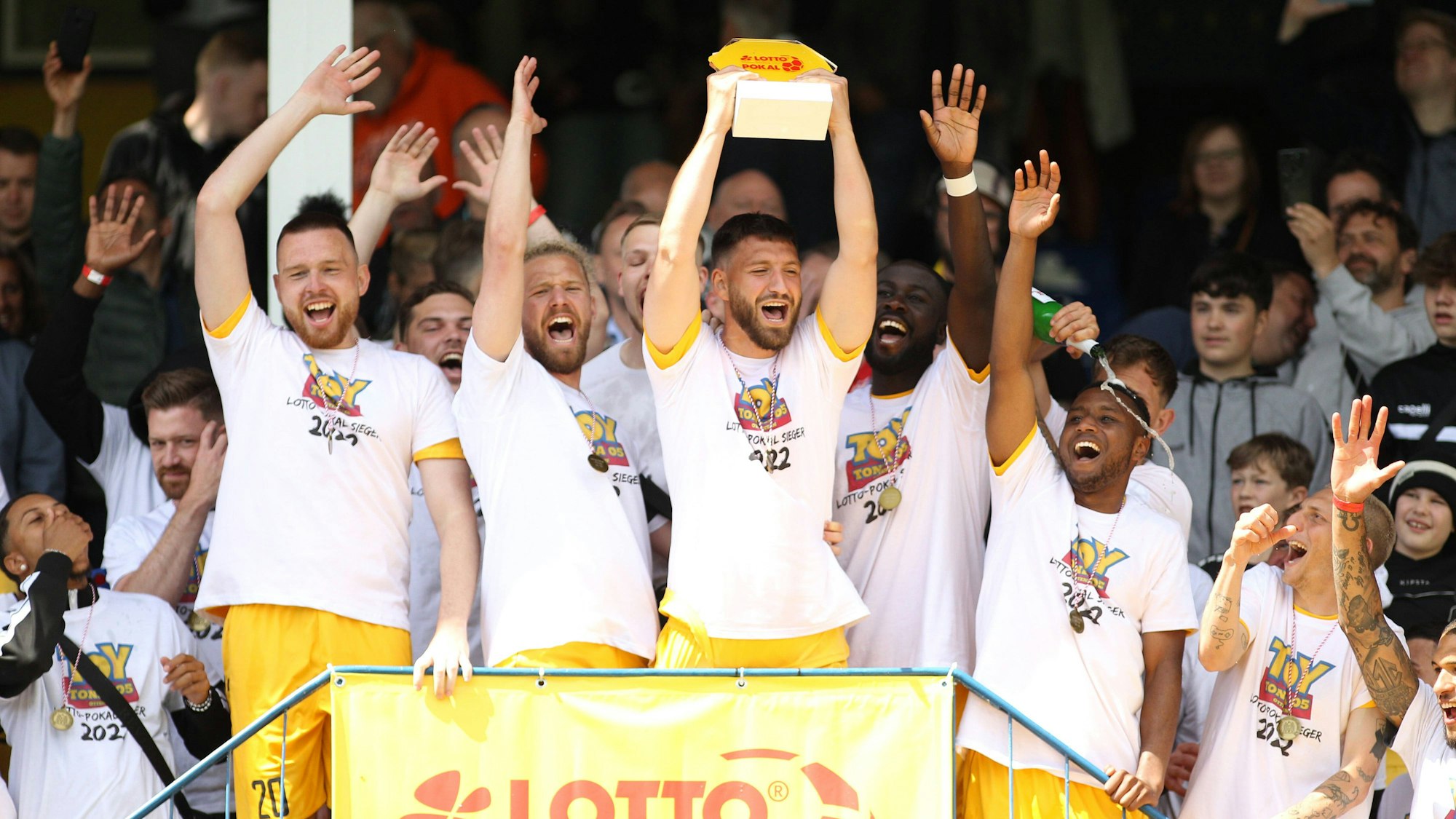Die Spieler des FC Teutonia Ottensen um Marcel Andrijanic mit Pokal in den Händen bejubeln den Sieg im Hamburger Verbandspokal.