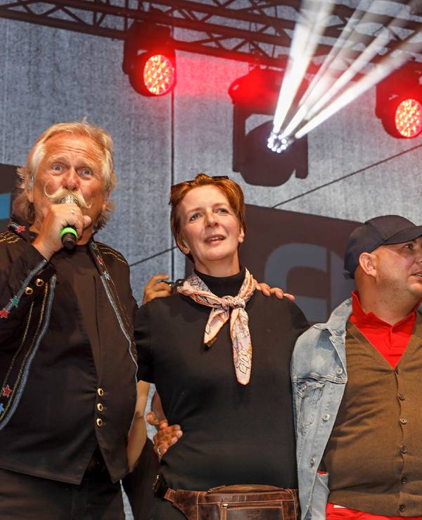 Henning Krautmacher und Patrick Lück von den Höhnern stehen mit Anke und Michael aus Duisburg auf der Bühne.