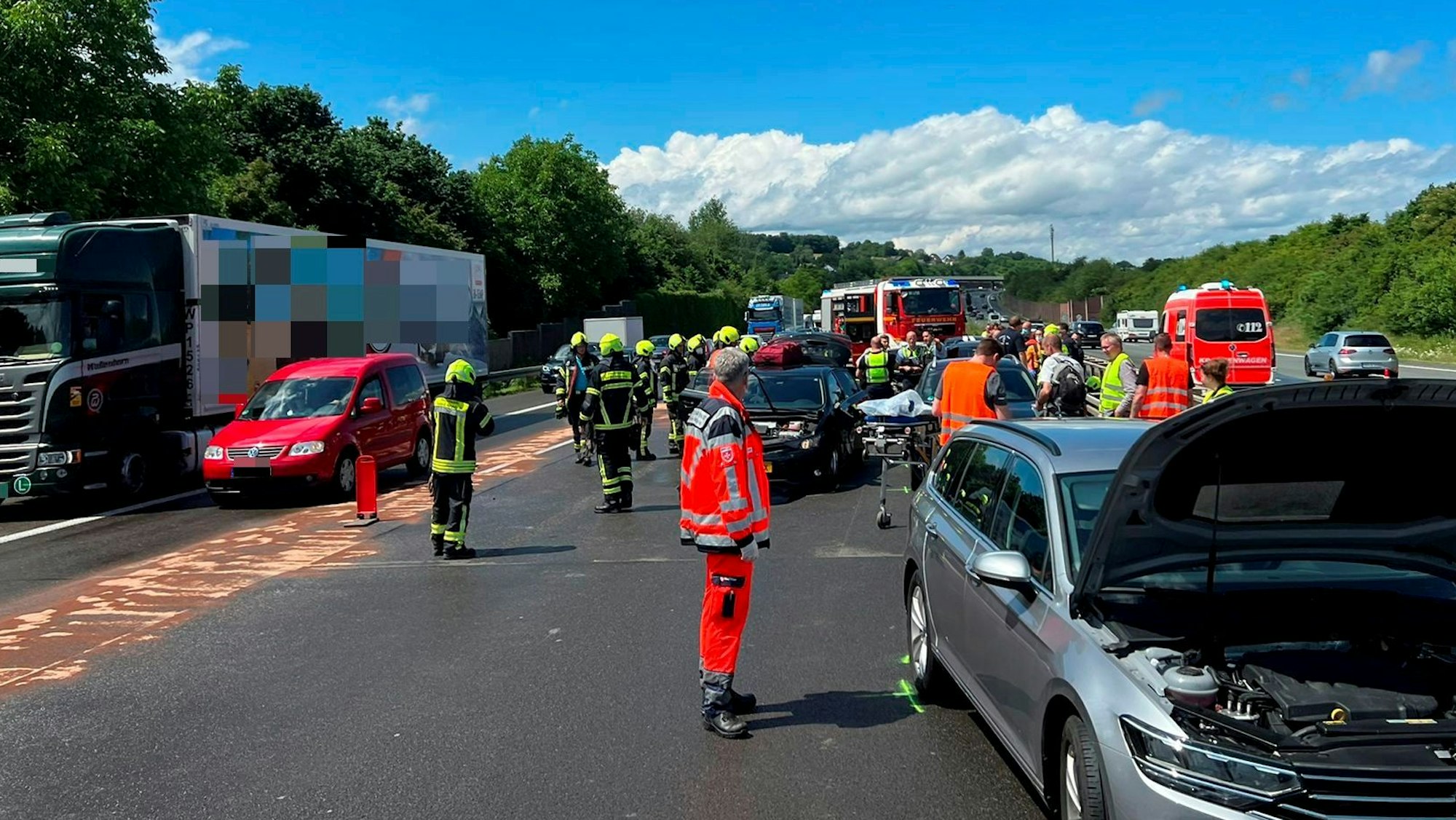 Zahlreiche Einsatzkräfte von Feuerwehr und Rettungsdienst sind auf einer Straße im Einsatz. Dort stehen drei Pkw und ein Lkw sowie mehrere Einsatzfahrzeuge.