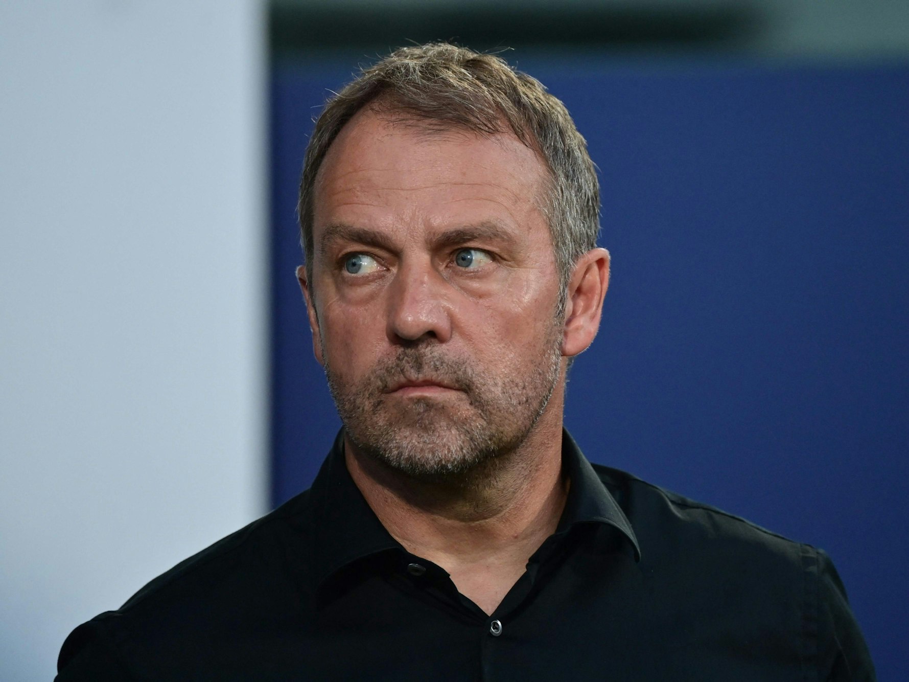 Bundestrainer Hansi Flick steht am Spielfeldrand.