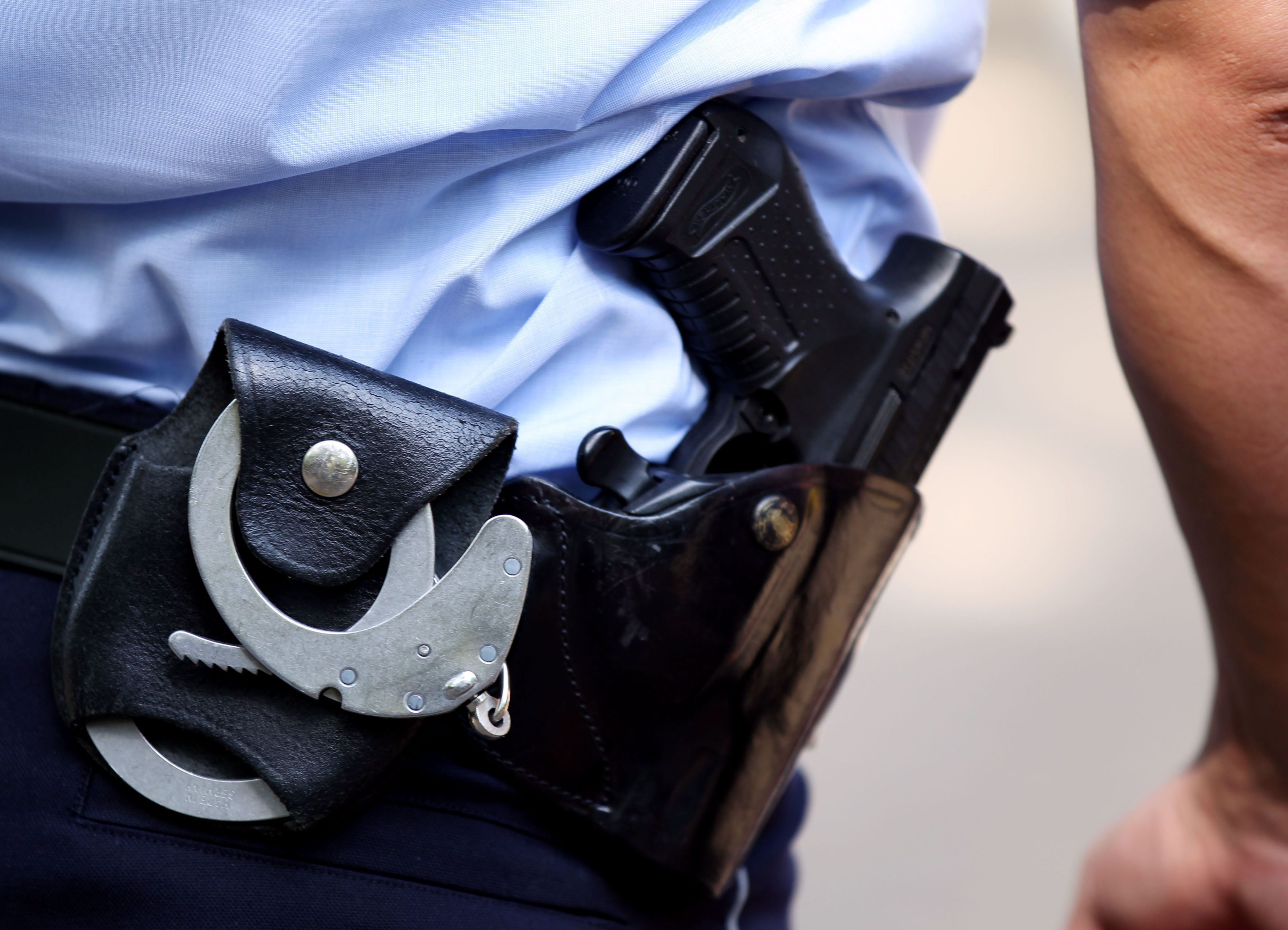 Ein Polizist mit Handschellen und Pistole am Gürtel.