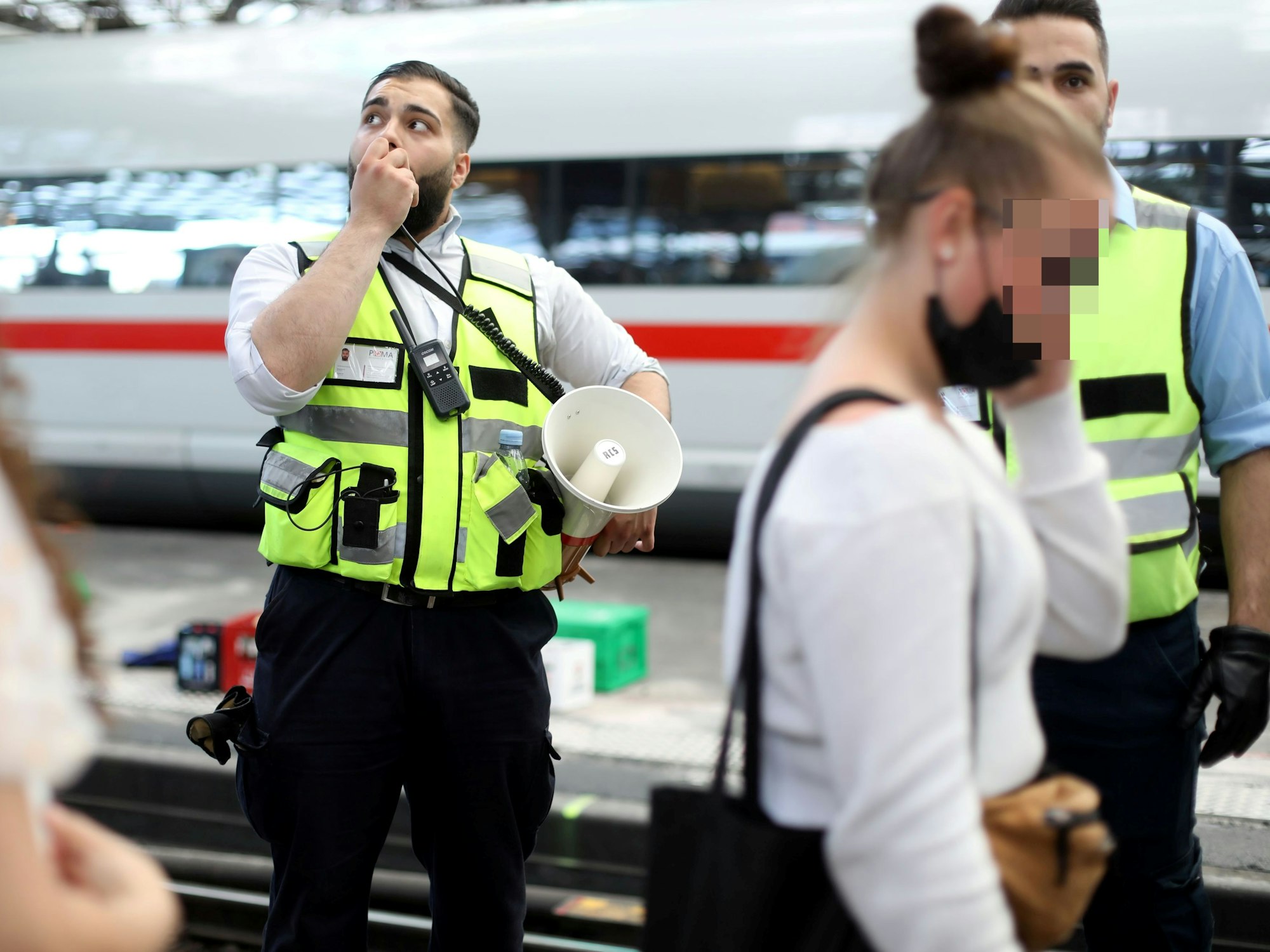 Um sich Gehör zu verschaffen greift ein Mitarbeiter der DB Sicherheit zum Megafon.