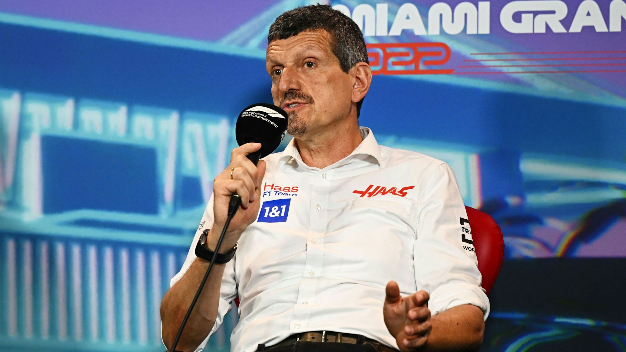 Günther Steiner hat ein Mikrofon in der Hand und spricht.