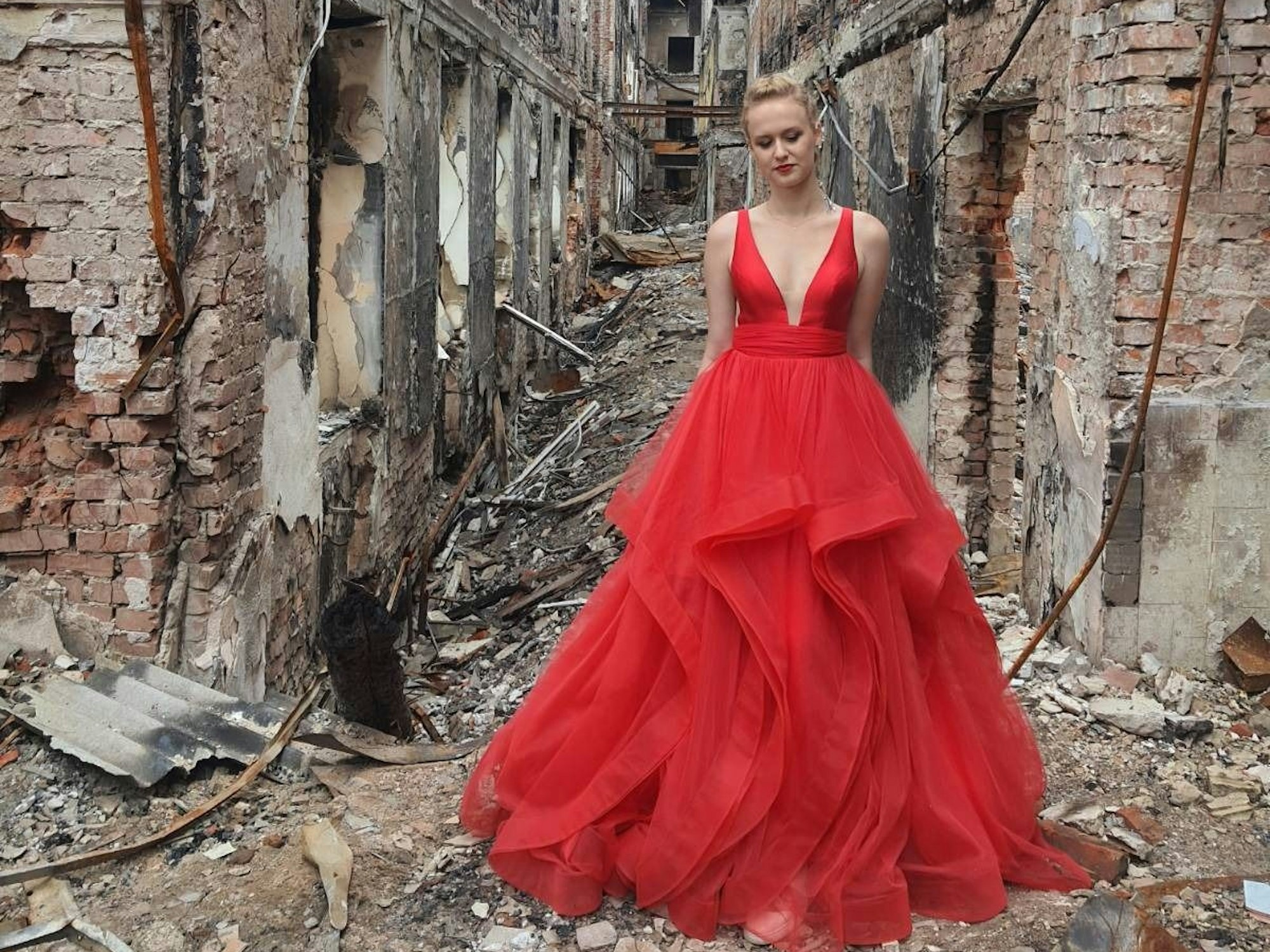 Valerie (16) aus Charkiw konnte nicht zu ihrem Schul-Abschlussball, weil Krieg herrschte. Nun kehrte sie an den Ort zurück, wo sie hätte feiern sollen, im roten Kleid. Ihre Tante teilte das Foto auf Facebook. Facebook/Anna Episheva