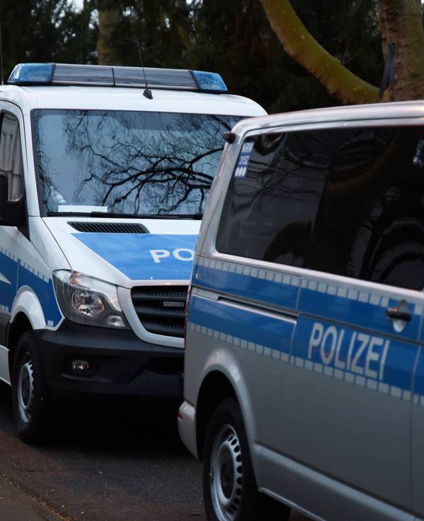 Das Symbolbild einer Razzia zeigt eine Reihe parkender Streifenwagen.