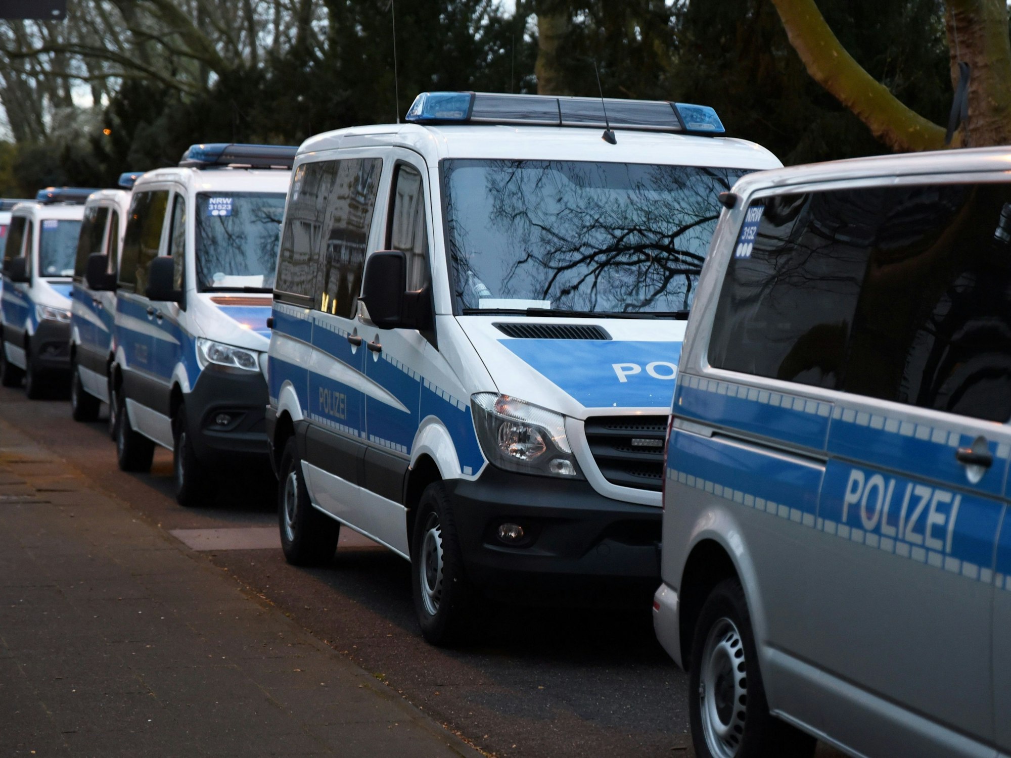 Das Symbolbild einer Razzia zeigt eine Reihe parkender Streifenwagen.