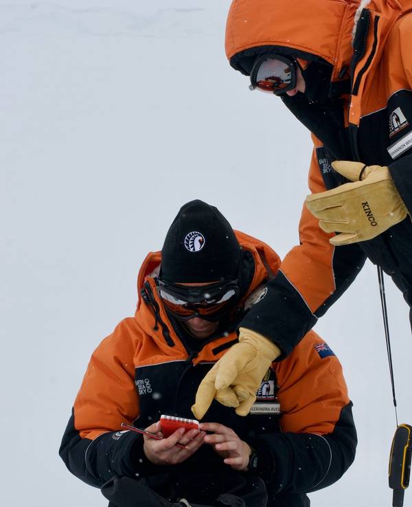 Die Studentin Alex Aves (l.) notiert Daten während der Probennahme von Schnee in der Antarktis. Sie hat im frisch gefallen Schnee einen schockierenden Fund gemacht.