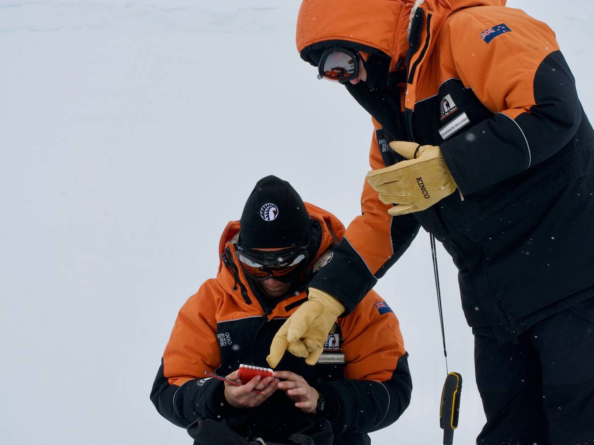 Die Studentin Alex Aves (l.) notiert Daten während der Probennahme von Schnee in der Antarktis. Sie hat im frisch gefallen Schnee einen schockierenden Fund gemacht.