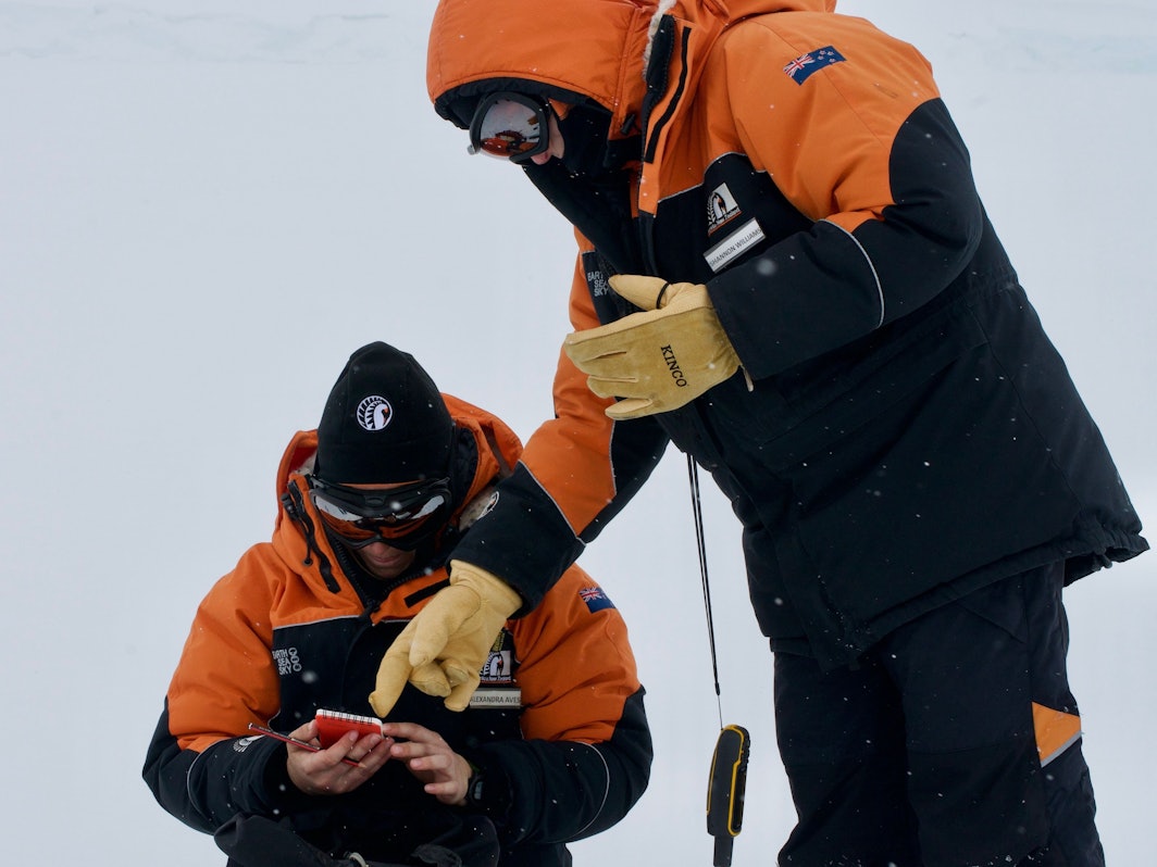 Die Studentin Alex Aves (l.) notiert Daten während der Probennahme von Schnee in der Antarktis. Sie hat im frisch gefallen Schnee einen schockierenden Fund gemacht.
