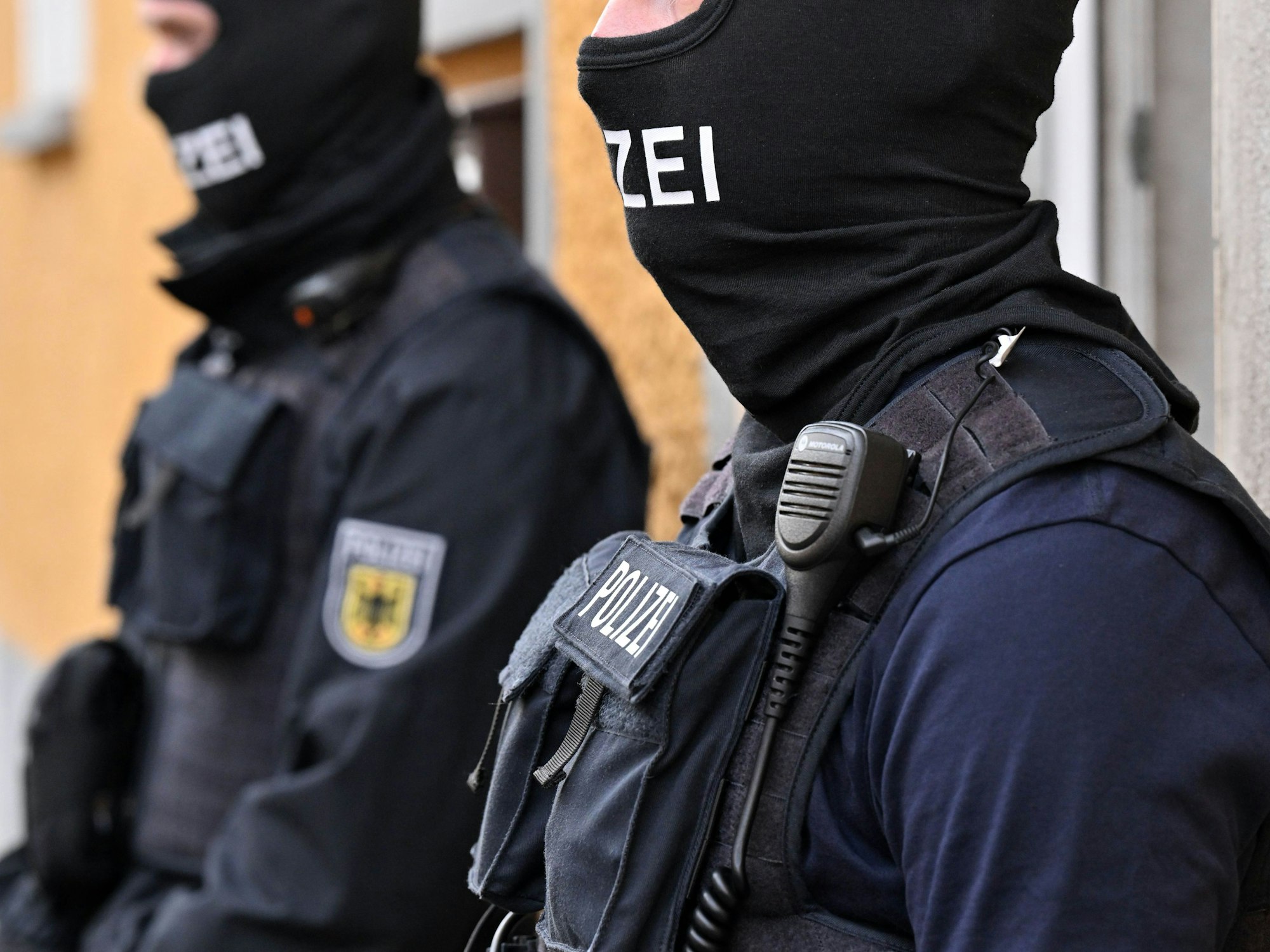 Bundespolizisten in Uniform stehen am 27. Mai 2022 vor Hauseingängen in Thüringen, Sachsen und Sachsen-Anhalt.