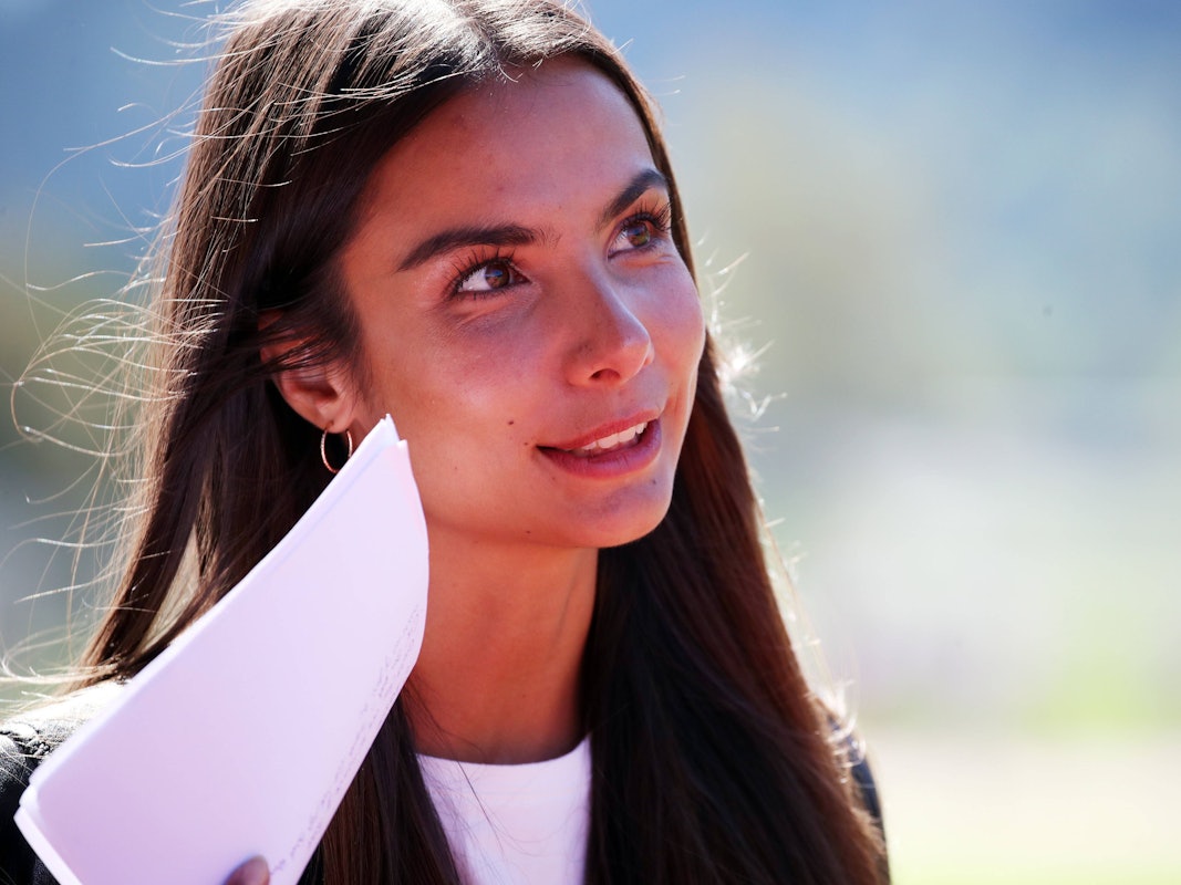 Lea Wagner lächelt und hat Arbeitsunterlagen in der Hand.