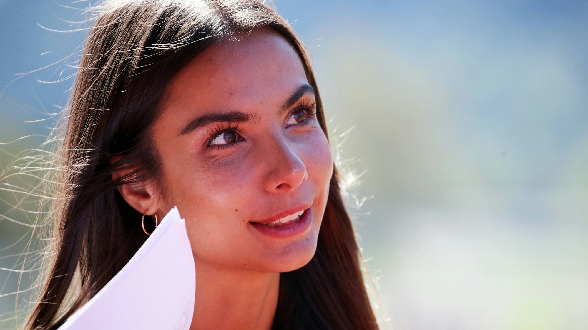 Lea Wagner lächelt und hat Arbeitsunterlagen in der Hand.