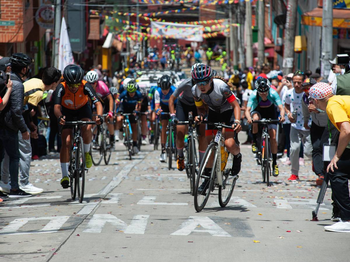 Die Rad-Profis kämpfen sich bei der Vuelta a Colombia auf einer schmalen Gasse den Berg hoch – Fans feuern von allen Seiten an.