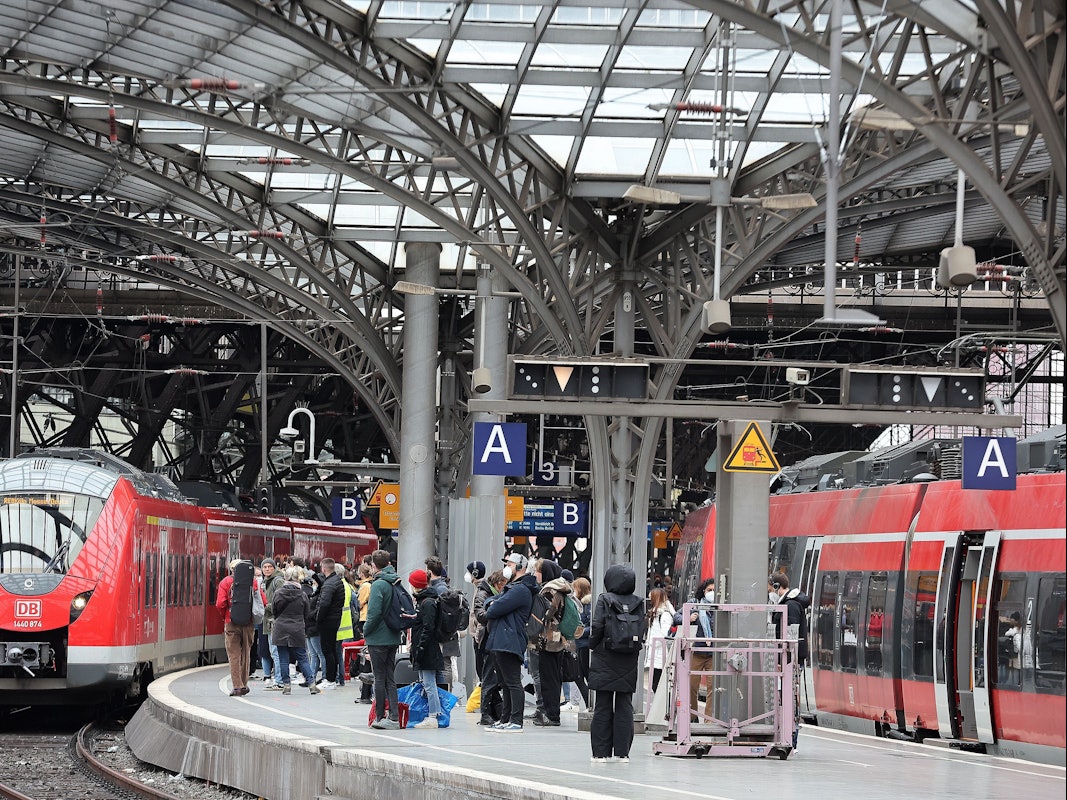 Am Kölner Hauptbahnhof fährt ein roter Zug der Deutschen Bahn ein.