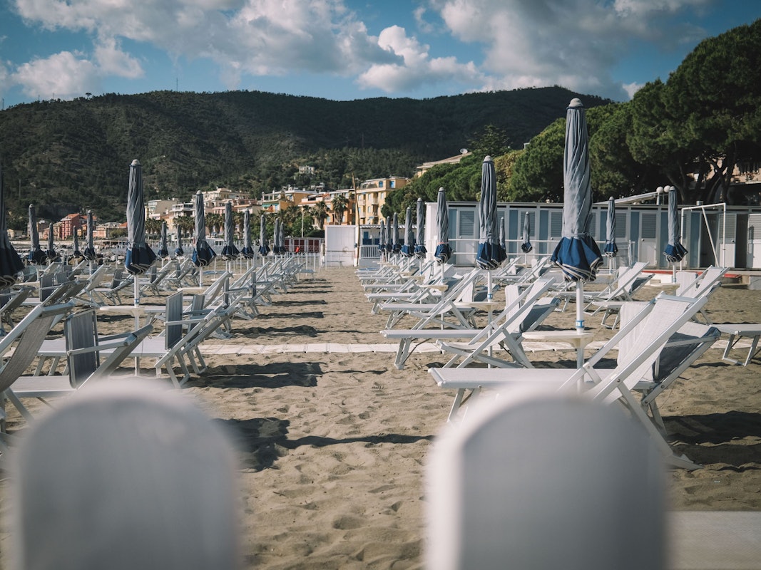 Liegestühle und Sonnenschirme stehen an einem Strand in Italien (Foto vom Mai 2020).