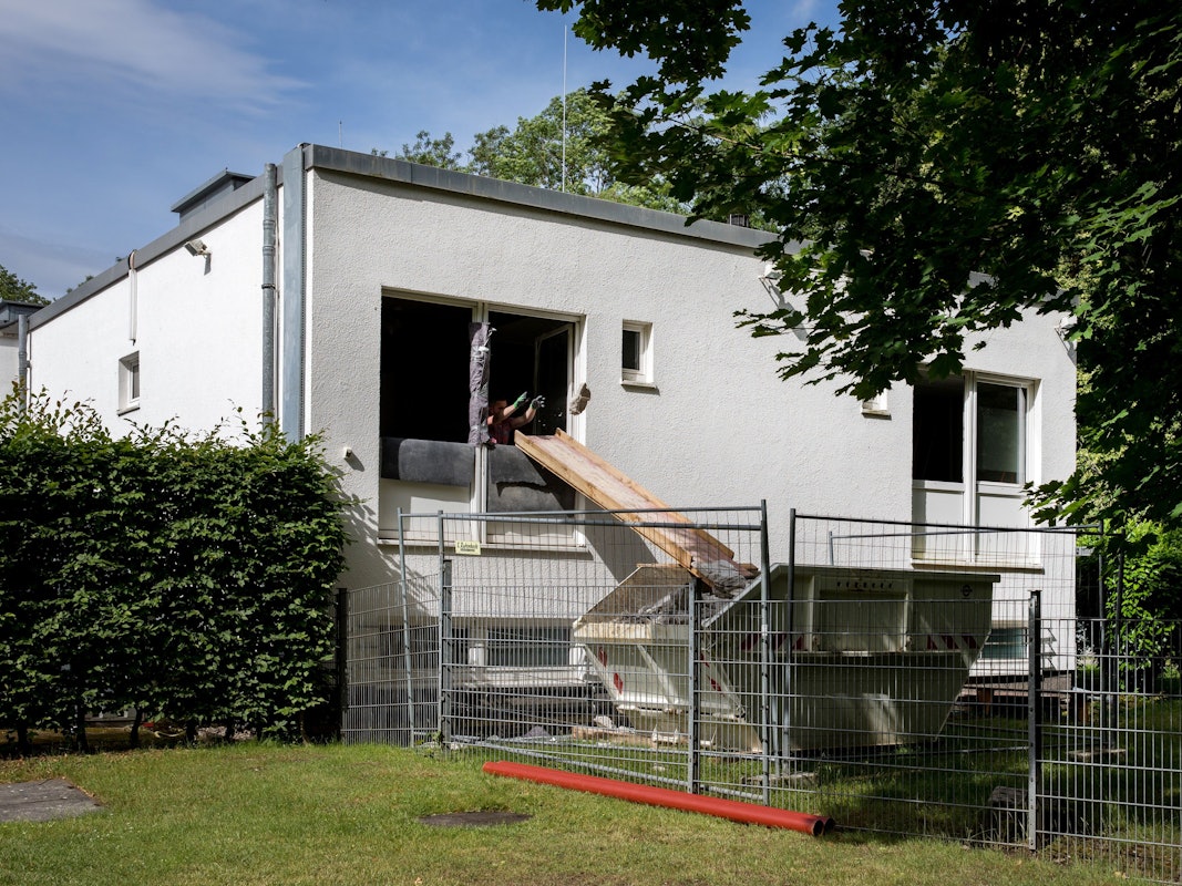 Arbeiter schmeißen am Geißbockheim Bau-Schutt in einen Container.