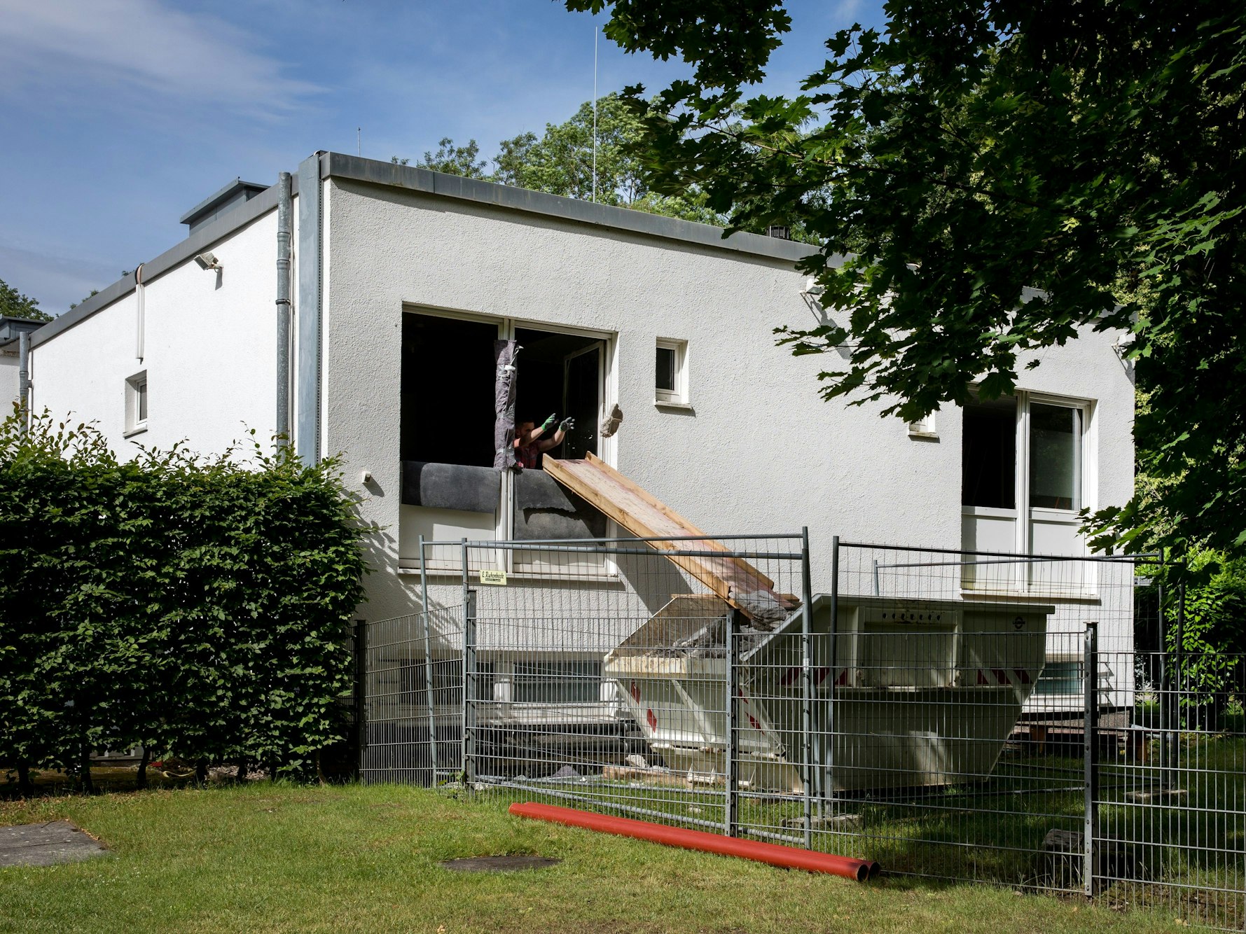 Arbeiter schmeißen am Geißbockheim Bau-Schutt in einen Container.
