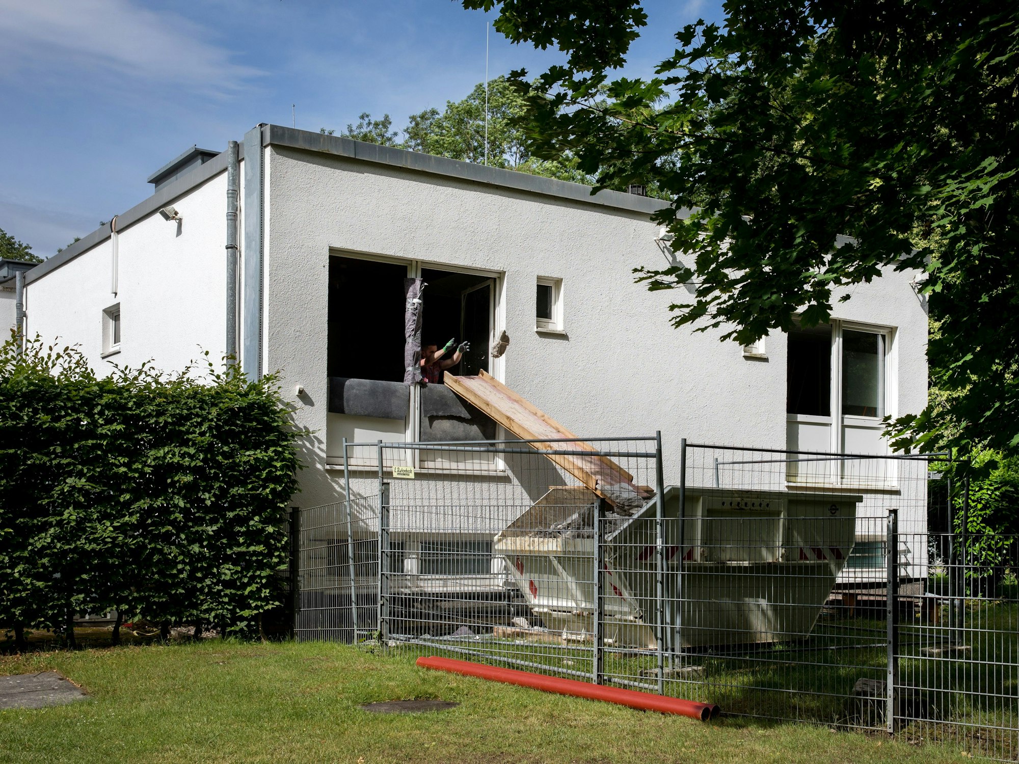 Arbeiter schmeißen am Geißbockheim Bau-Schutt in einen Container.