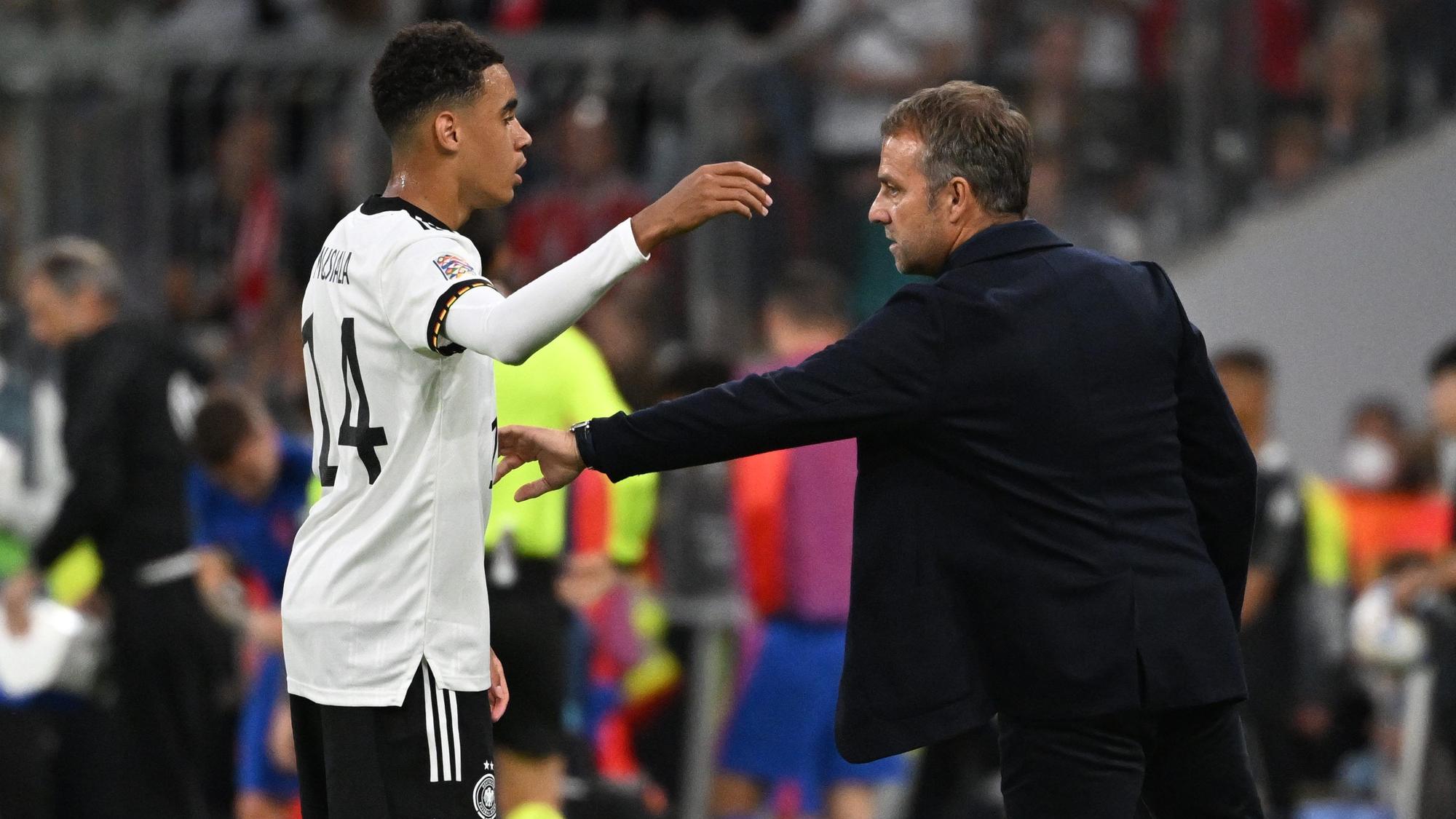 Bundestrainer Hansi Flick und Jamal Musiala unterhalten sich während des Spiels.