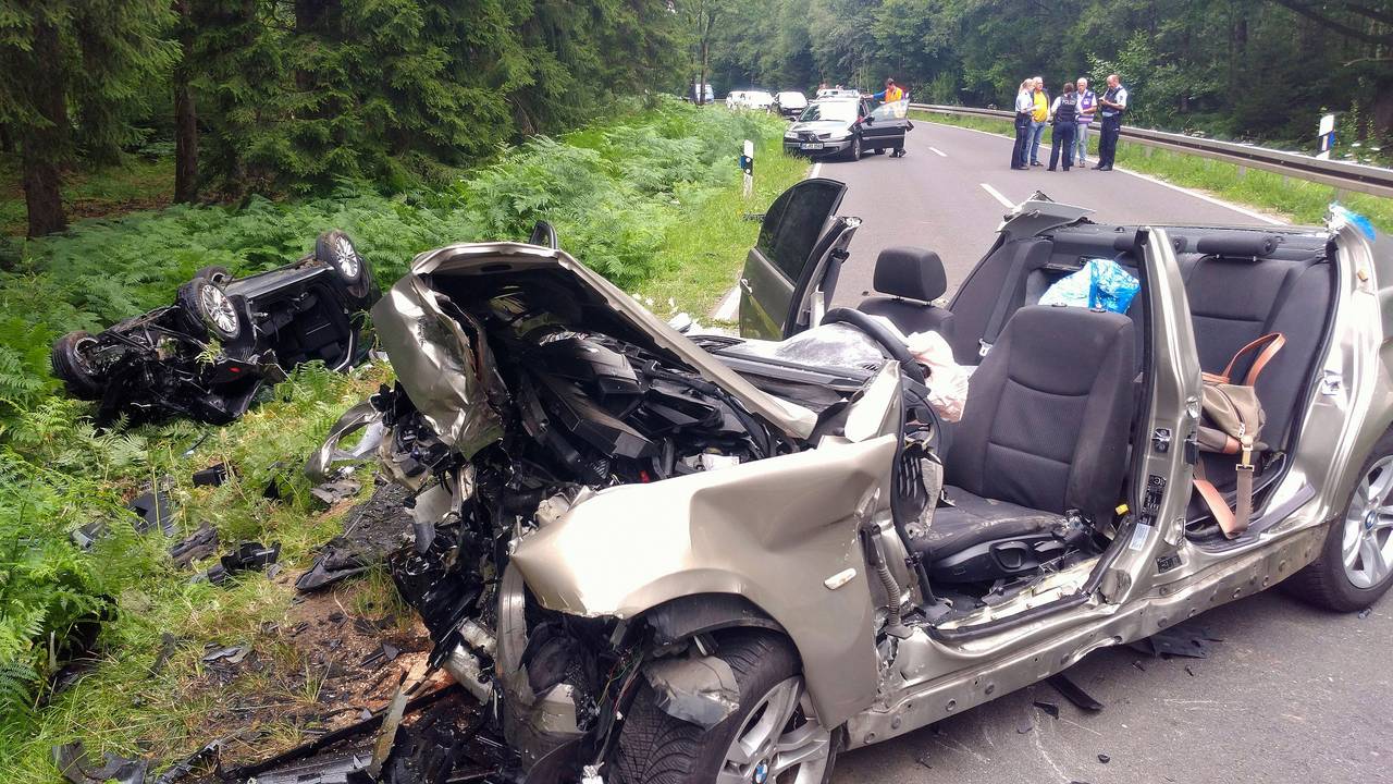 Zwei vollkommen zerstörte Autos liegen nach einem Unfall am Rand der Landstraße L12 zwischen Roetgen und Simmerath in der Eifel. Vier Personen wurden bei dem Zusammenstoß schwer verletzt, davon starb ein Kind später im Krankenhaus.