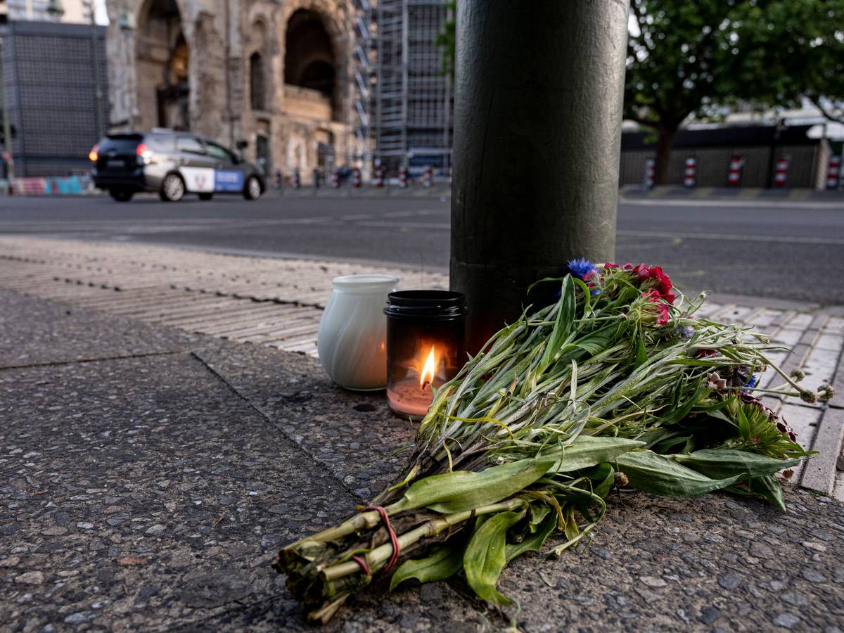 Kerzen und ein Blumenstrauß liegen auf dem Bürgersteig an der Tauentzienstraße in Berlin