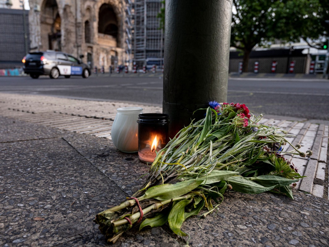 Kerzen und ein Blumenstrauß liegen auf dem Bürgersteig an der Tauentzienstraße in Berlin