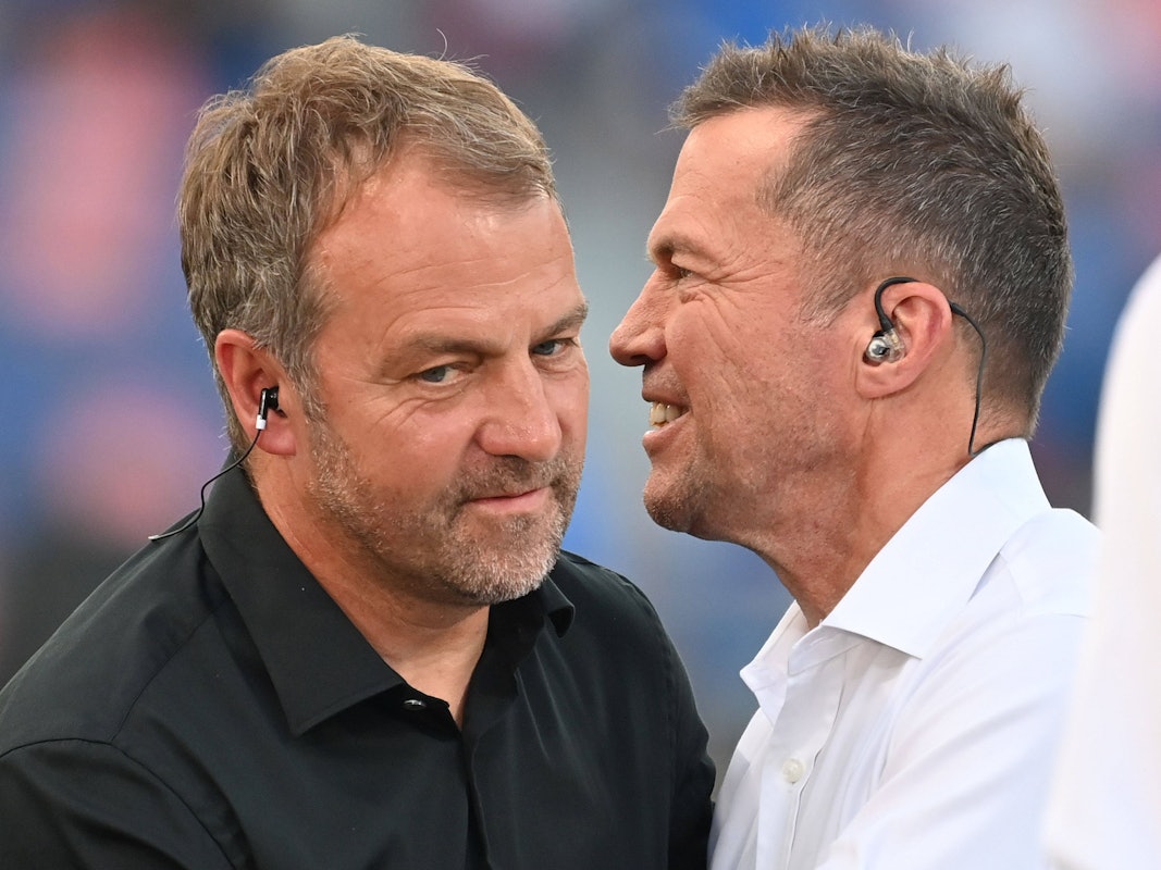 Hansi Flick unterhält sich mit Lothar Matthäus am Spielfeldrand.