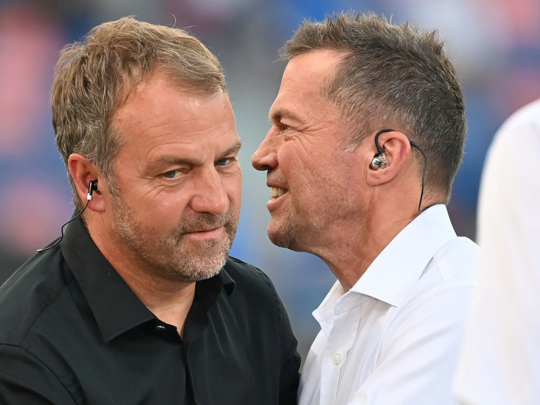 Hansi Flick unterhält sich mit Lothar Matthäus am Spielfeldrand.