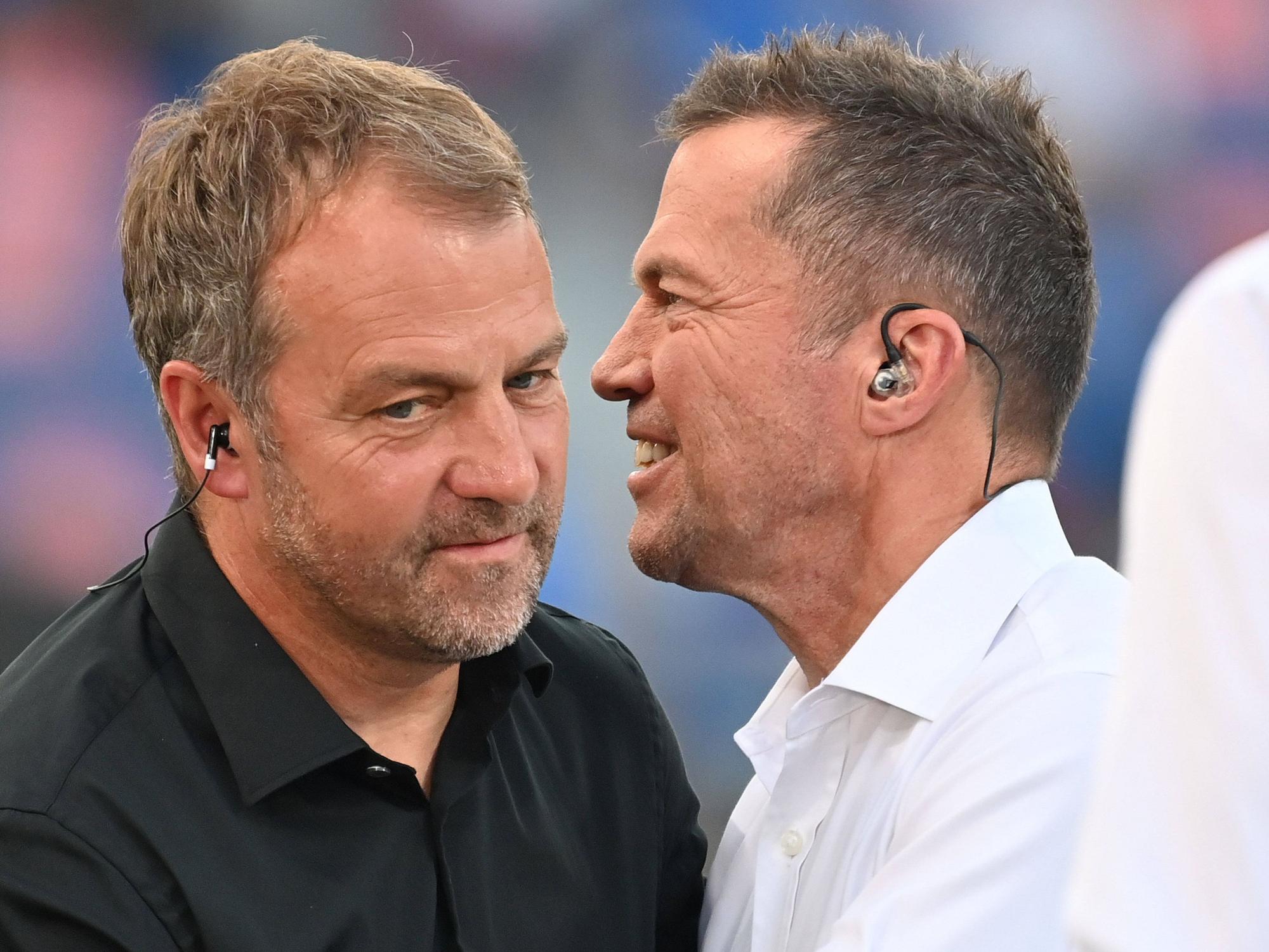 Hansi Flick unterhält sich mit Lothar Matthäus am Spielfeldrand.