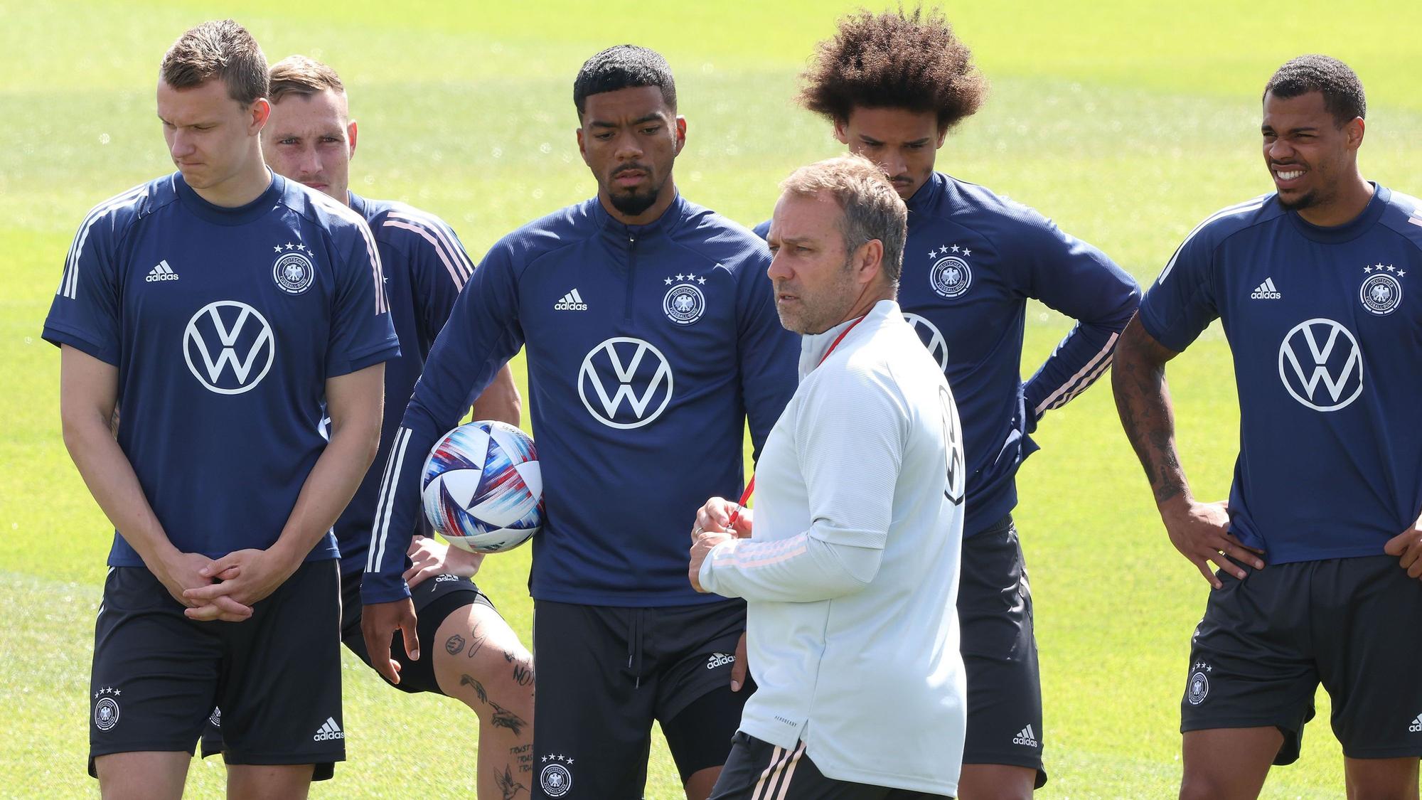 Hansi Flick spricht mit seinen Spielern auf dem Trainingsplatz.