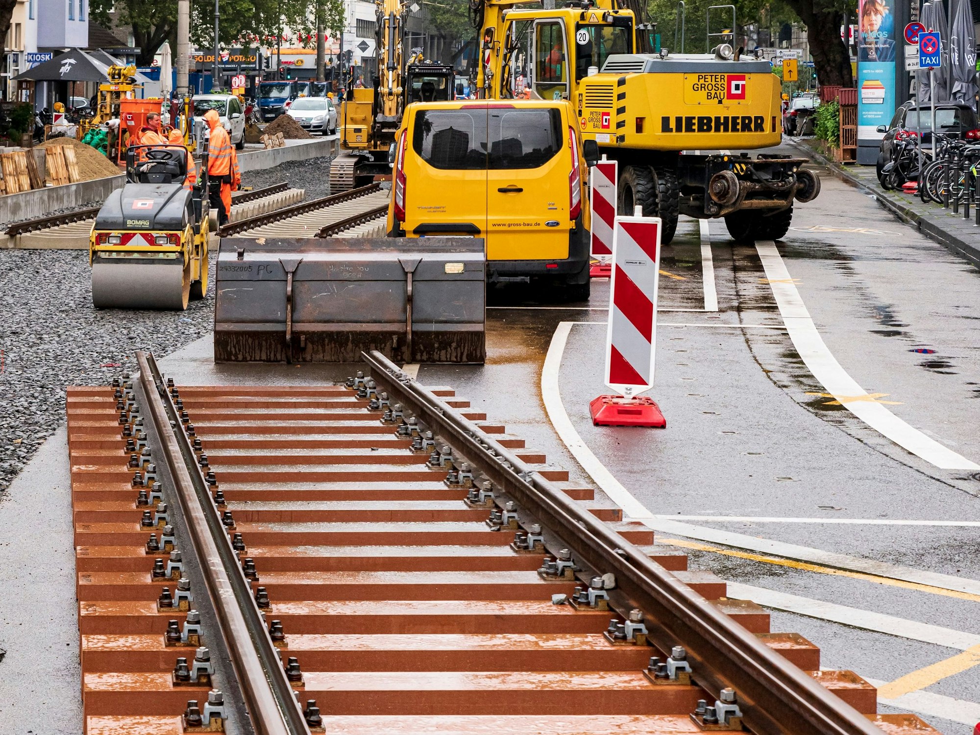 Großbaustelle der Kölner Verkehrs-Betriebe auf dem Zülpicher Platz, bzw. zwischen dem Zülpicher Platz und dem Barbarossaplatz. Neue Gleise liegen auf der Straße, Baufahrzeuge stehen bereit.