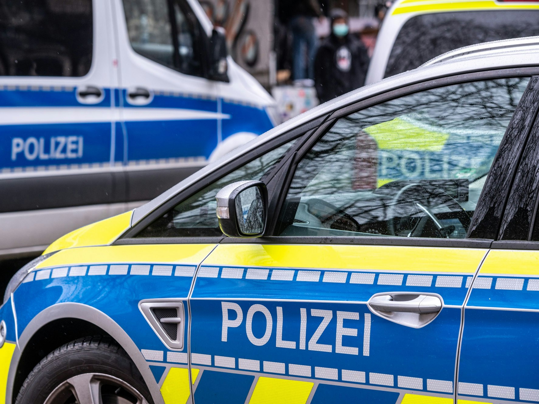Fahrzeuge der Polizei stehen an der Straße.