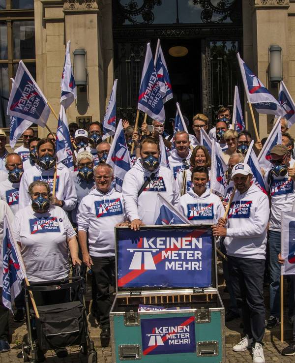 Das Bild vom 10. Juni 2022 zeigt die Menschen mit Schildern und Fahnen, welche mit dem Kampagnen-Motto „Keinen Meter mehr“ bedruckt sind.