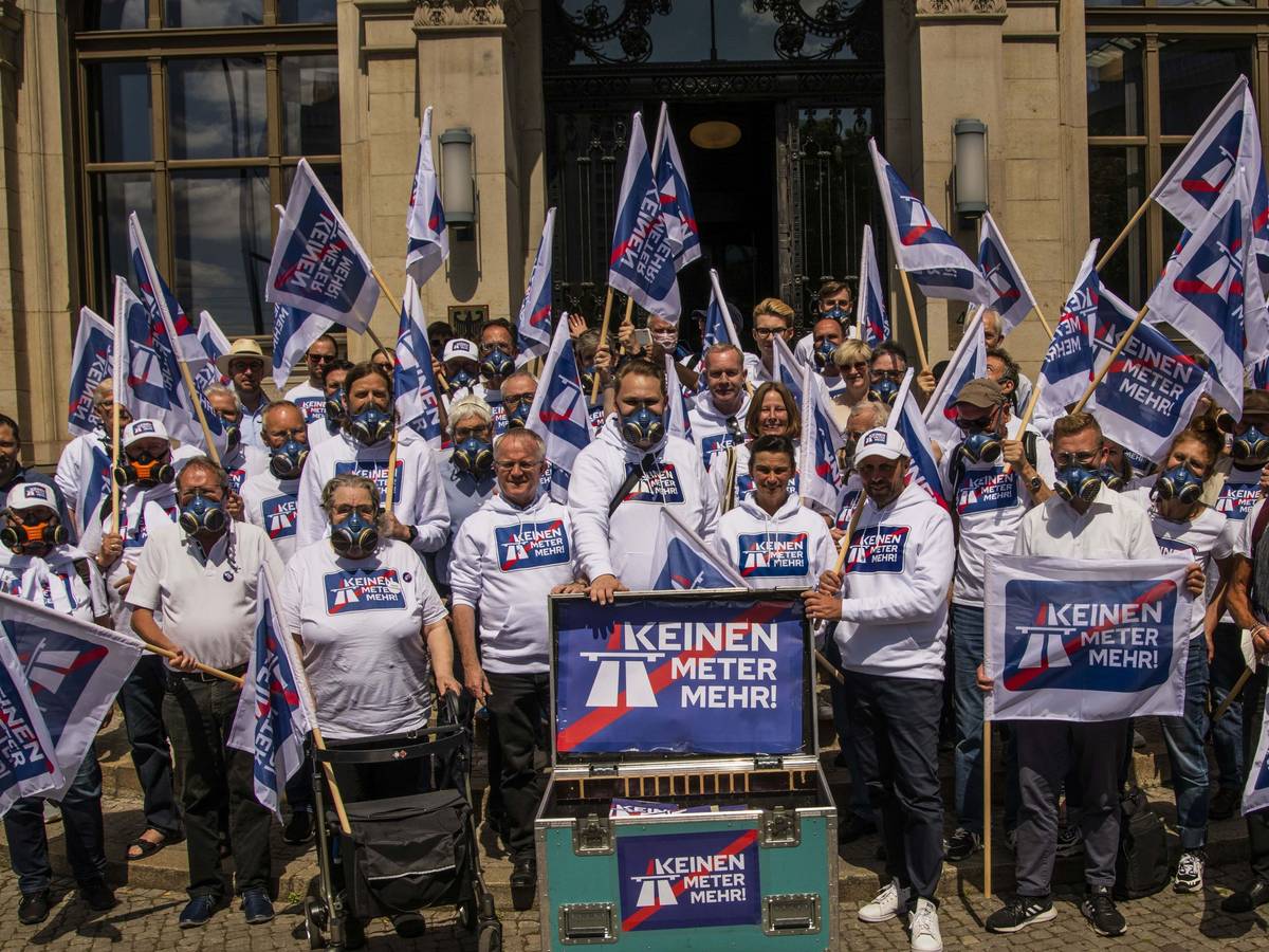 Das Bild vom 10. Juni 2022 zeigt die Menschen mit Schildern und Fahnen, welche mit dem Kampagnen-Motto „Keinen Meter mehr“ bedruckt sind.