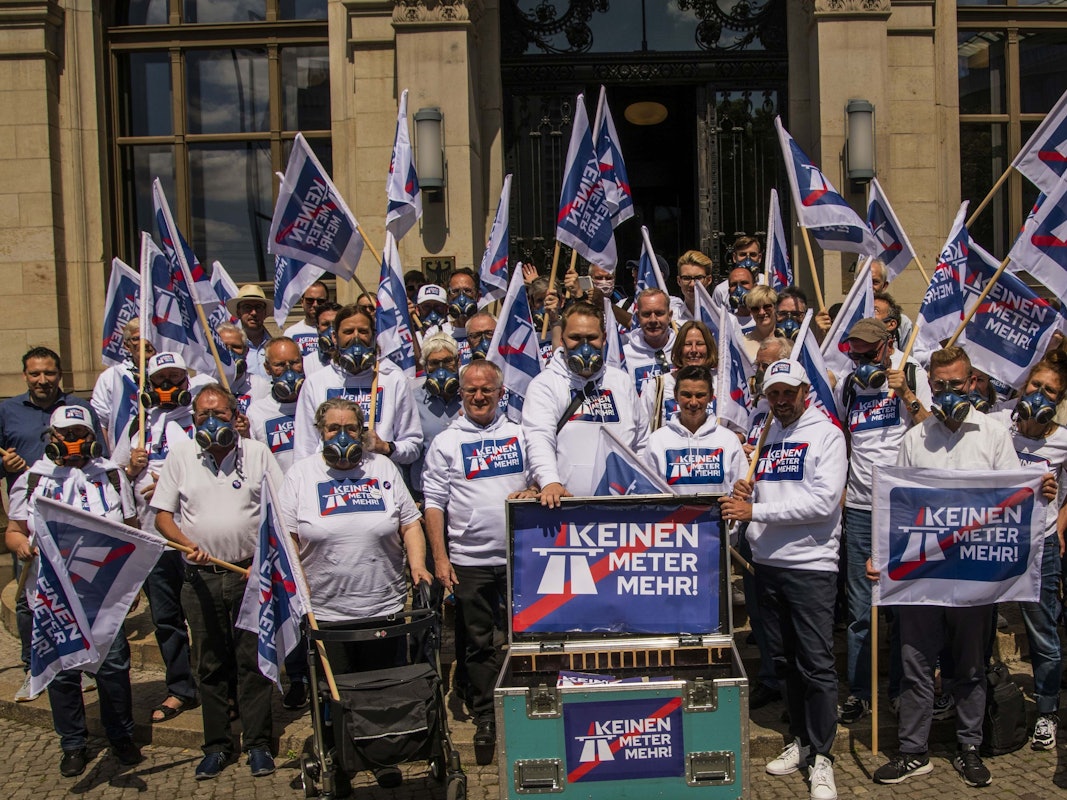 Das Bild vom 10. Juni 2022 zeigt die Menschen mit Schildern und Fahnen, welche mit dem Kampagnen-Motto „Keinen Meter mehr“ bedruckt sind.