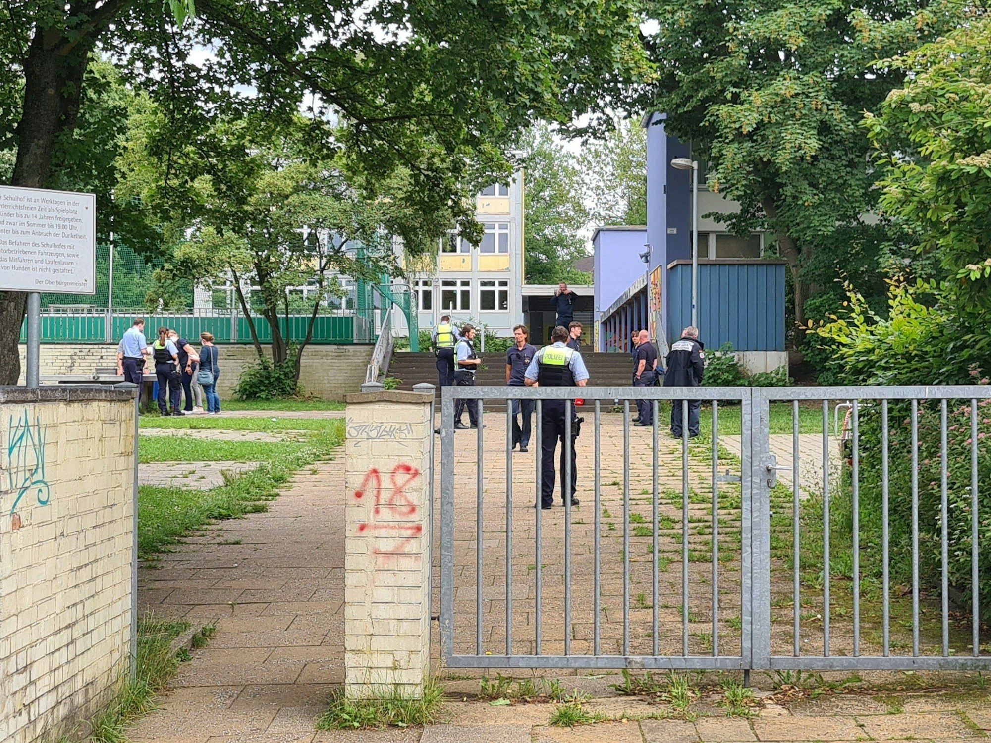 Einsatzkräfte stehen im Eingangsbereich einer Schule. An einer Essener Realschule haben Schüler aus einer Flasche eine unbekannte Flüssigkeit getrunken und danach massive gesundheitliche Probleme bekommen.