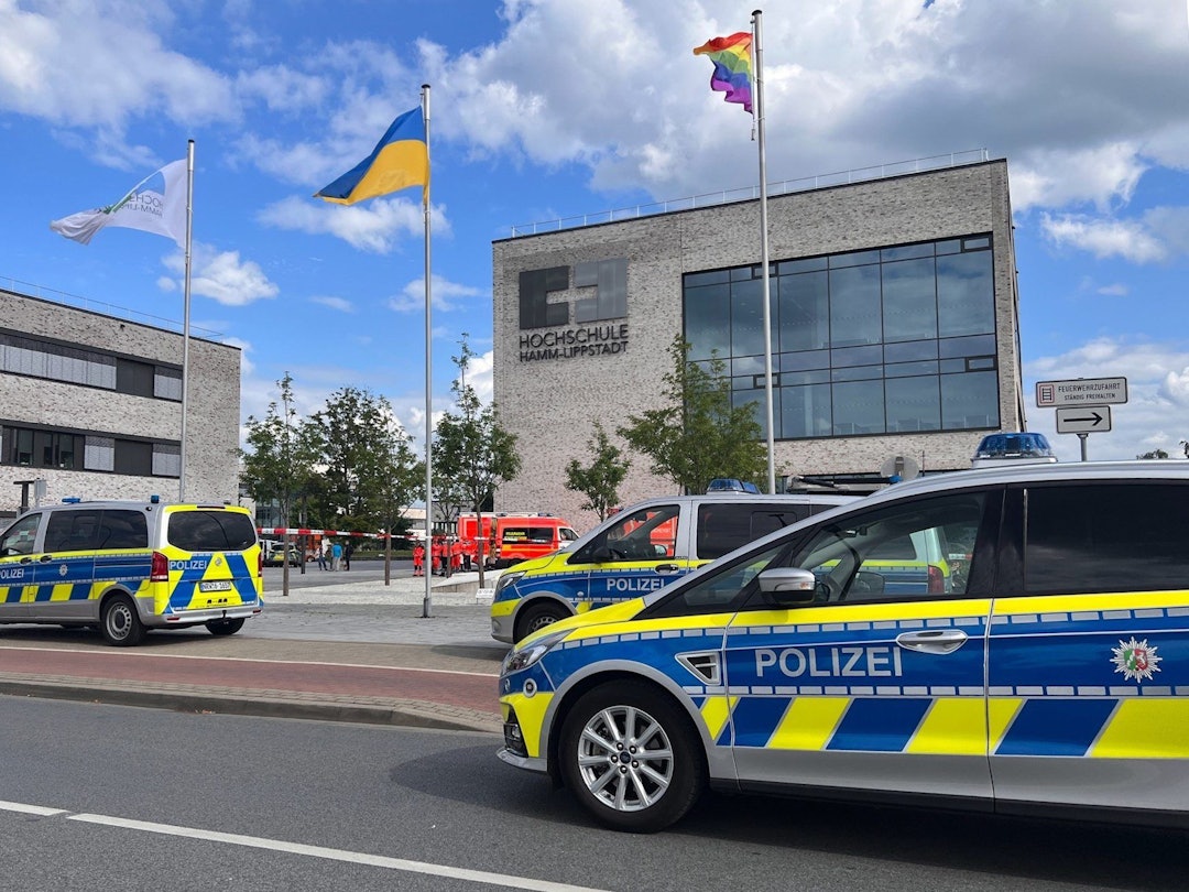 Einsatzfahrzeuge der Polizei stehen vor dem Gebäude der Hochschule Hamm-Lippstadt. An der Hochschule Hamm-Lippstadt hat ein 34-jähriger Mann mit einem Messer mehrere Menschen angegriffen und vier Personen verletzt, einige von ihnen schwer. Er wurde von Studenten überwältigt und festgehalten, bis Polizisten ihn festnahmen.
