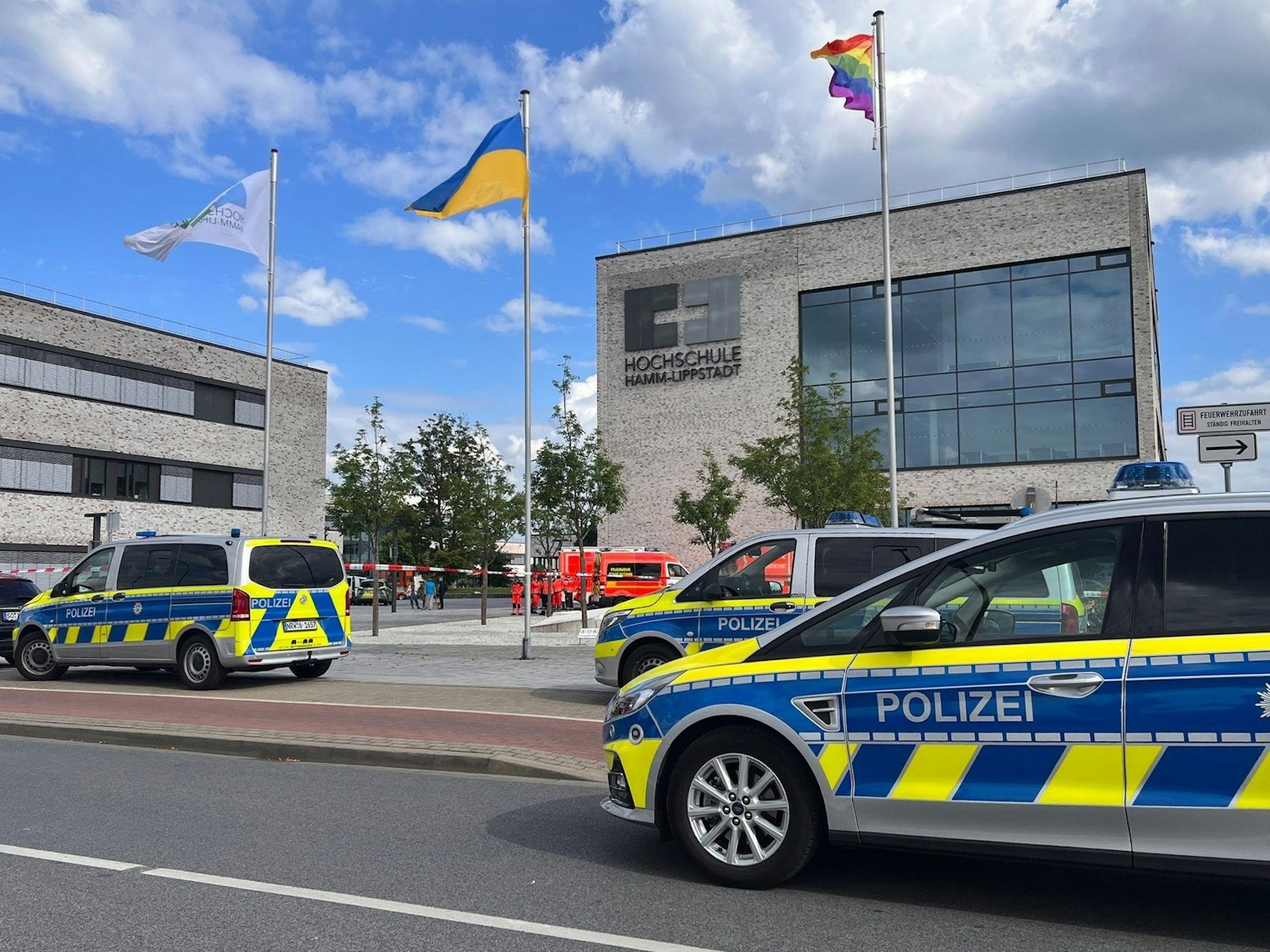 Einsatzfahrzeuge der Polizei stehen vor dem Gebäude der Hochschule Hamm-Lippstadt. An der Hochschule Hamm-Lippstadt hat ein 34-jähriger Mann mit einem Messer mehrere Menschen angegriffen und vier Personen verletzt, einige von ihnen schwer. Er wurde von Studenten überwältigt und festgehalten, bis Polizisten ihn festnahmen.