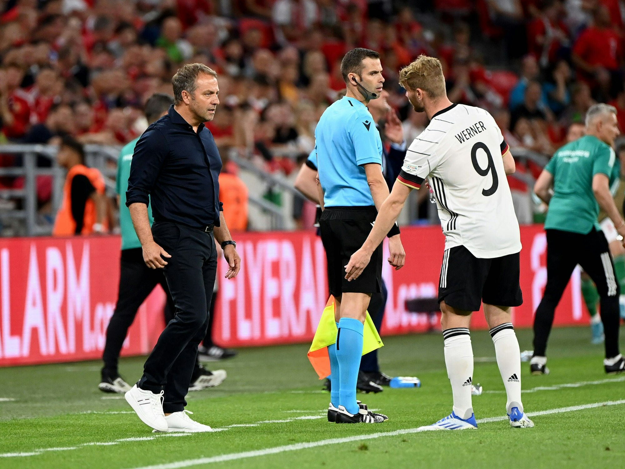 Hansi Flick und Timo Werner diskutieren am Spielfeldrand miteinander.