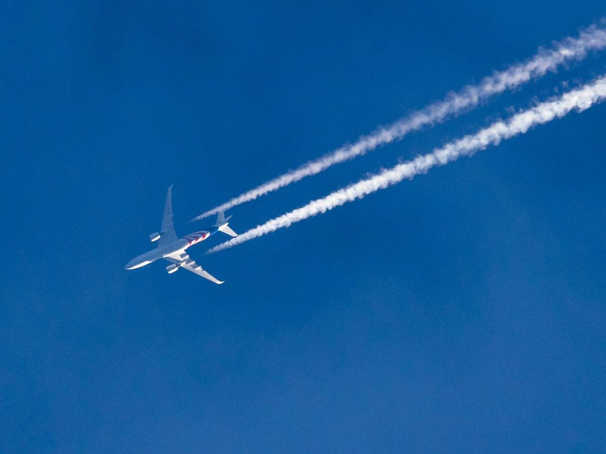 Ein Flugzeug am Himmel über einer Stadt.
