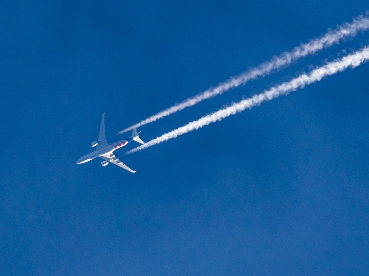 Ein Flugzeug am Himmel über einer Stadt.