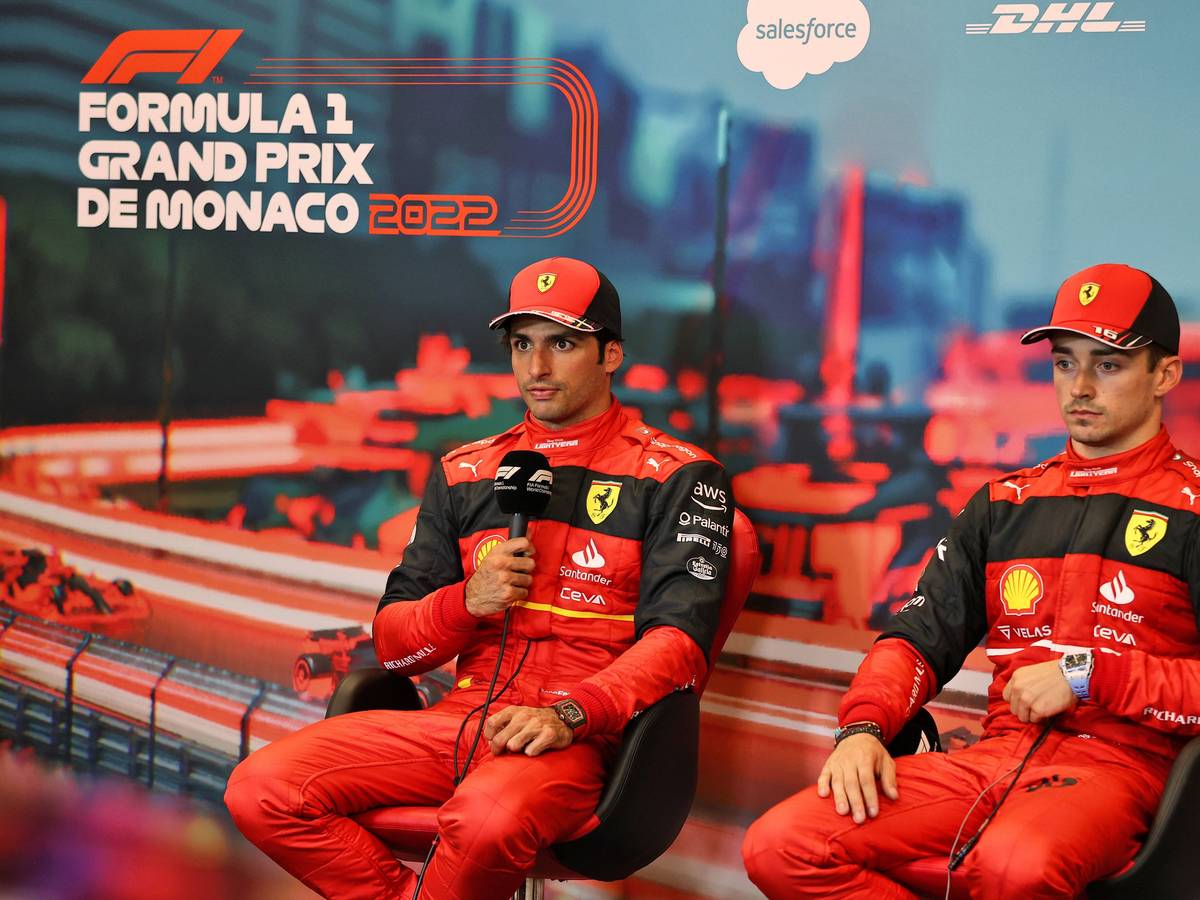 Carlos Sainz hält auf einer Pressekonferenz das Mikrofon in der Hand und spricht mit den Journalisten, daneben sein Teamkollege Charles Leclerc.