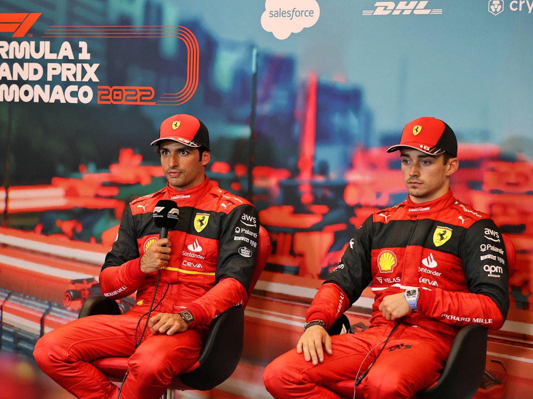 Carlos Sainz hält auf einer Pressekonferenz das Mikrofon in der Hand und spricht mit den Journalisten, daneben sein Teamkollege Charles Leclerc.