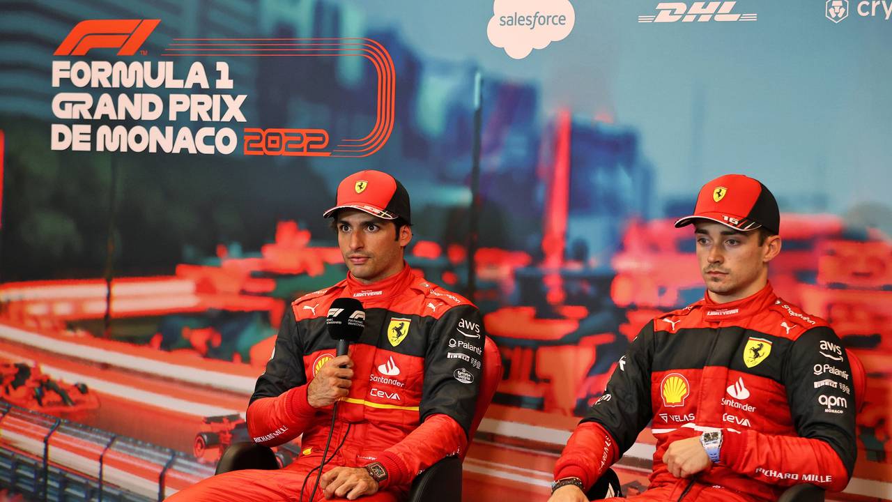 Carlos Sainz hält auf einer Pressekonferenz das Mikrofon in der Hand und spricht mit den Journalisten, daneben sein Teamkollege Charles Leclerc.