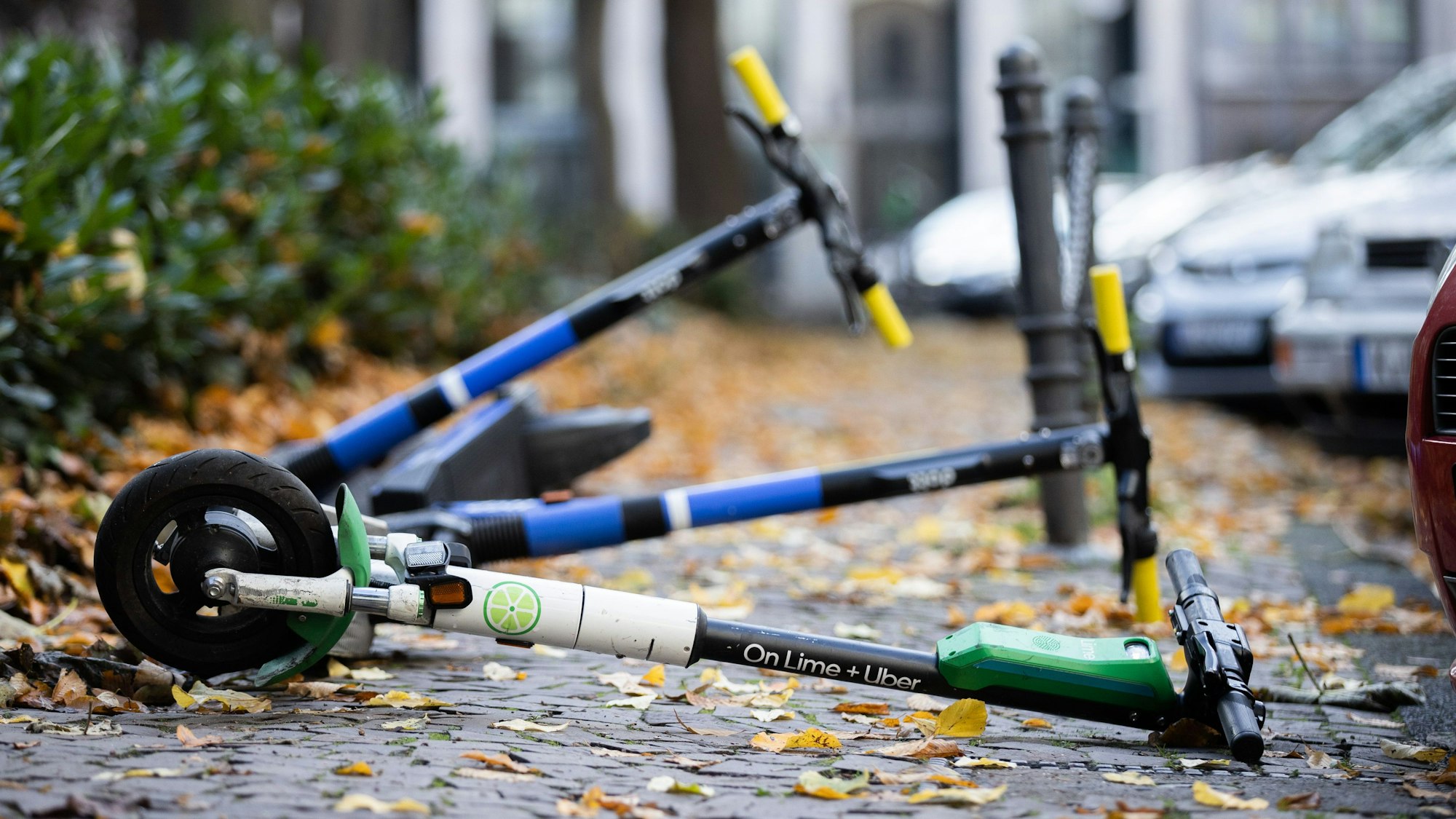 E-Scooter liegen auf einem Gehweg.
