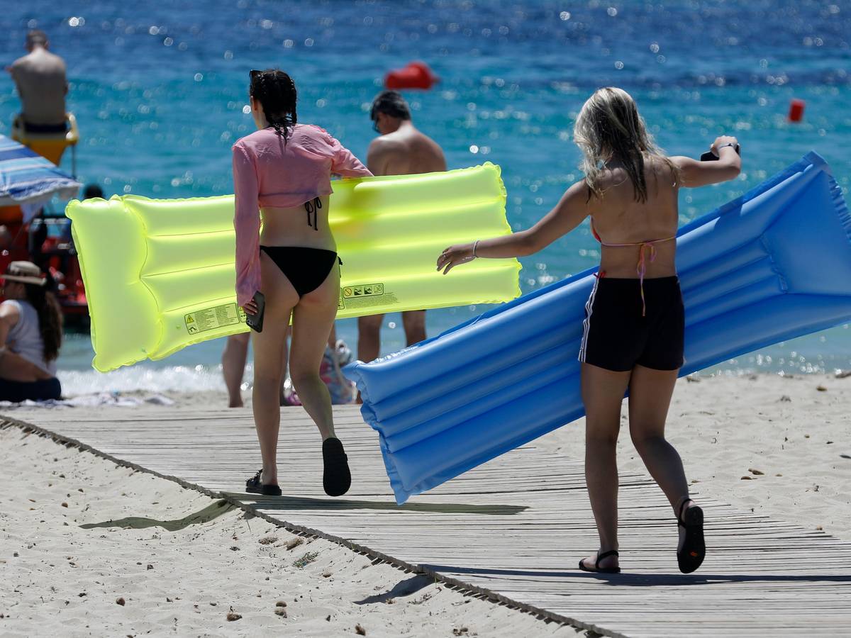 Menschen sonnen sich am Strand von Palmanova auf Mallorca.
