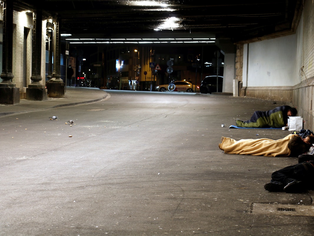 Obdachlose in Schlafsäcken in einer Unterführung.