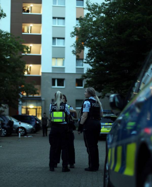 Beamte der Polizei Köln bei Ermittlungen vor ihrem Dienstwagen